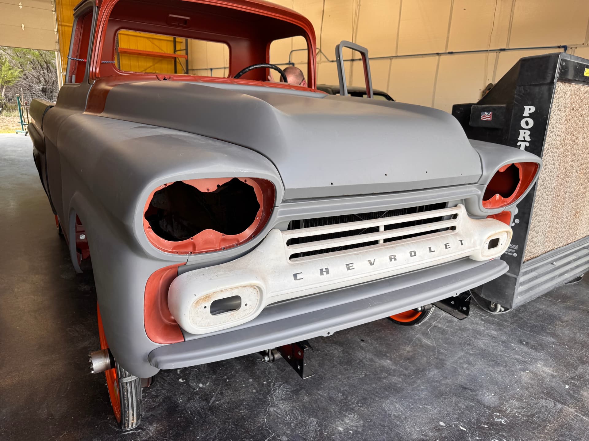 Front clip in primer with the Chevrolet grille bar hung for fit.