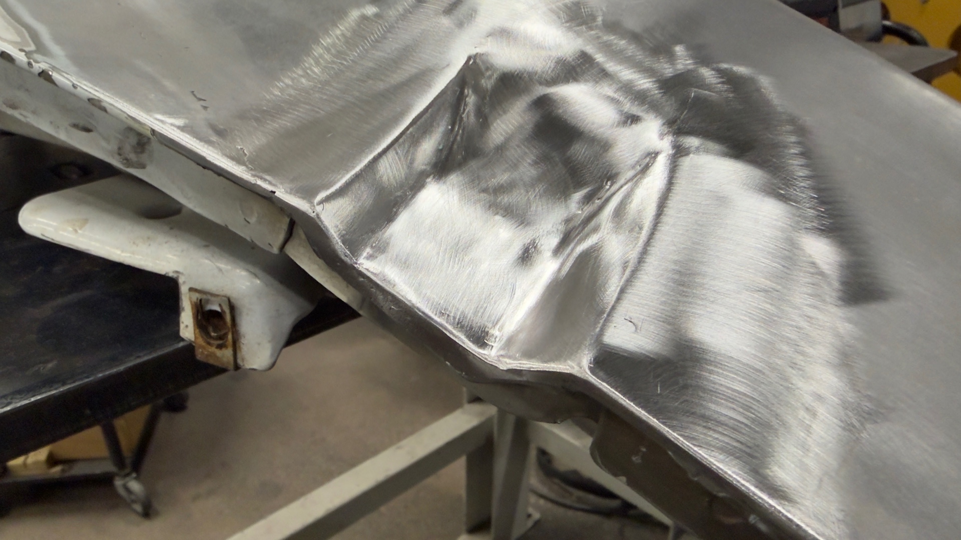 Sculpted contour worked into an aluminum panel — shaped by hand, no filler.