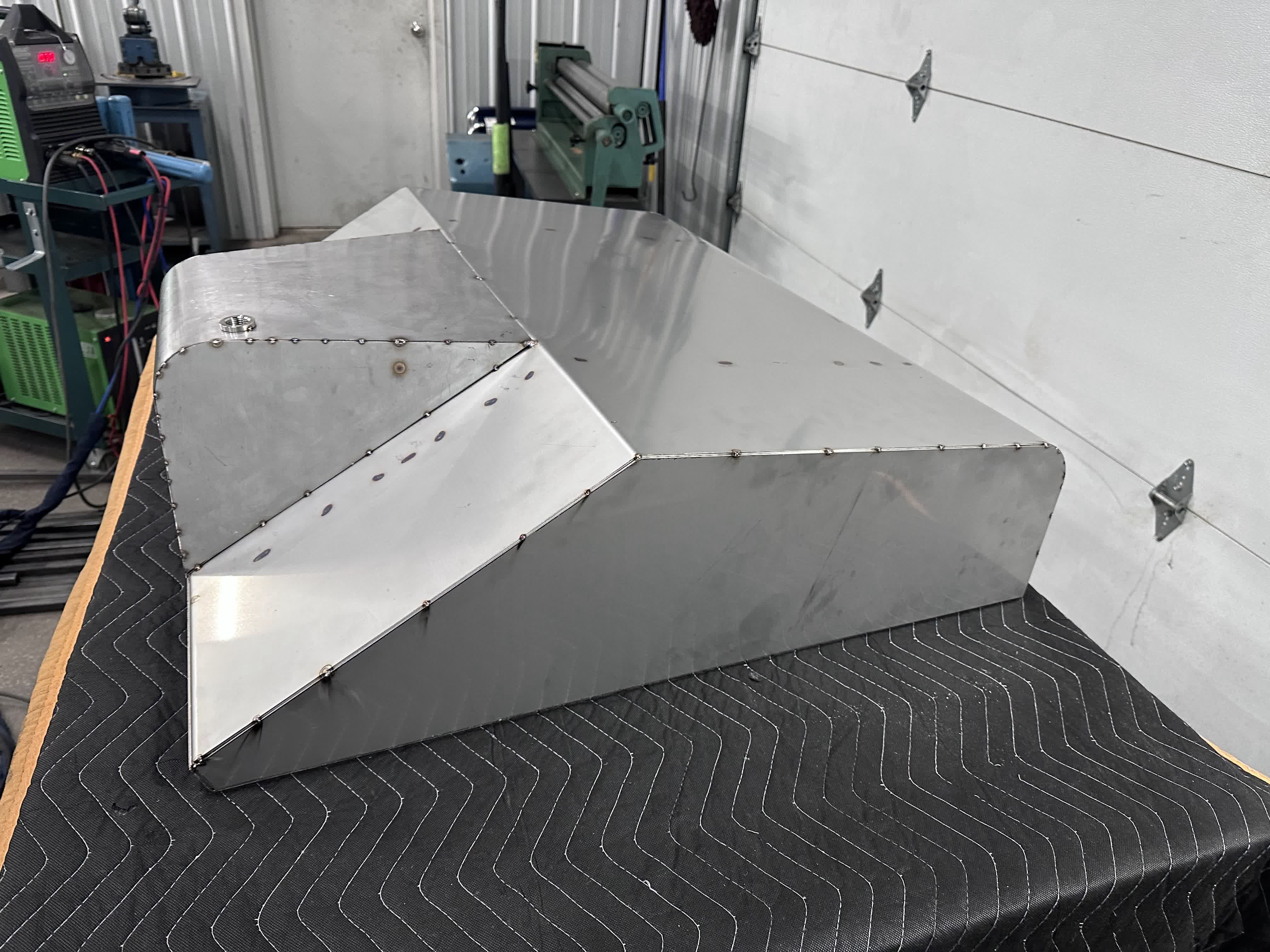 Side profile of the clecoed tank showing the angled forward face that tucks around the frame.