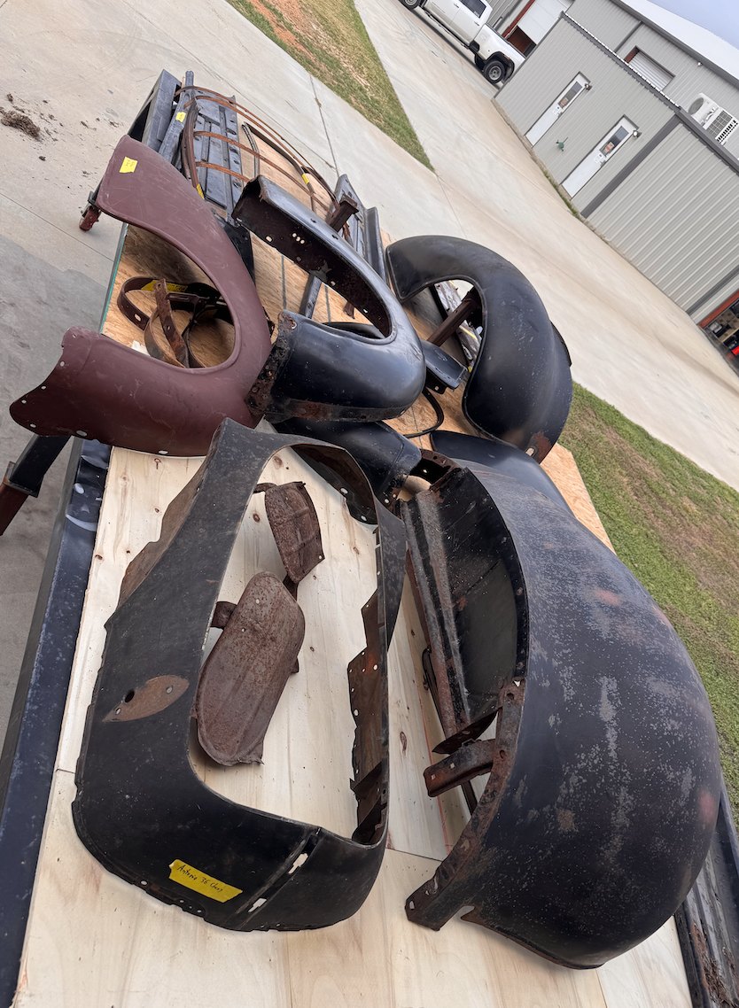 Original fenders and body panels laid out — next to be stripped.