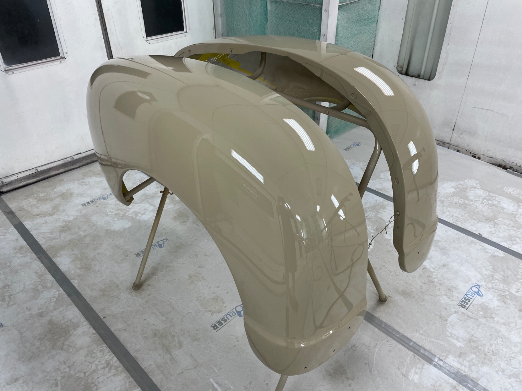 Front and rear fenders in fresh color — glass-smooth reflections coming off the block work.