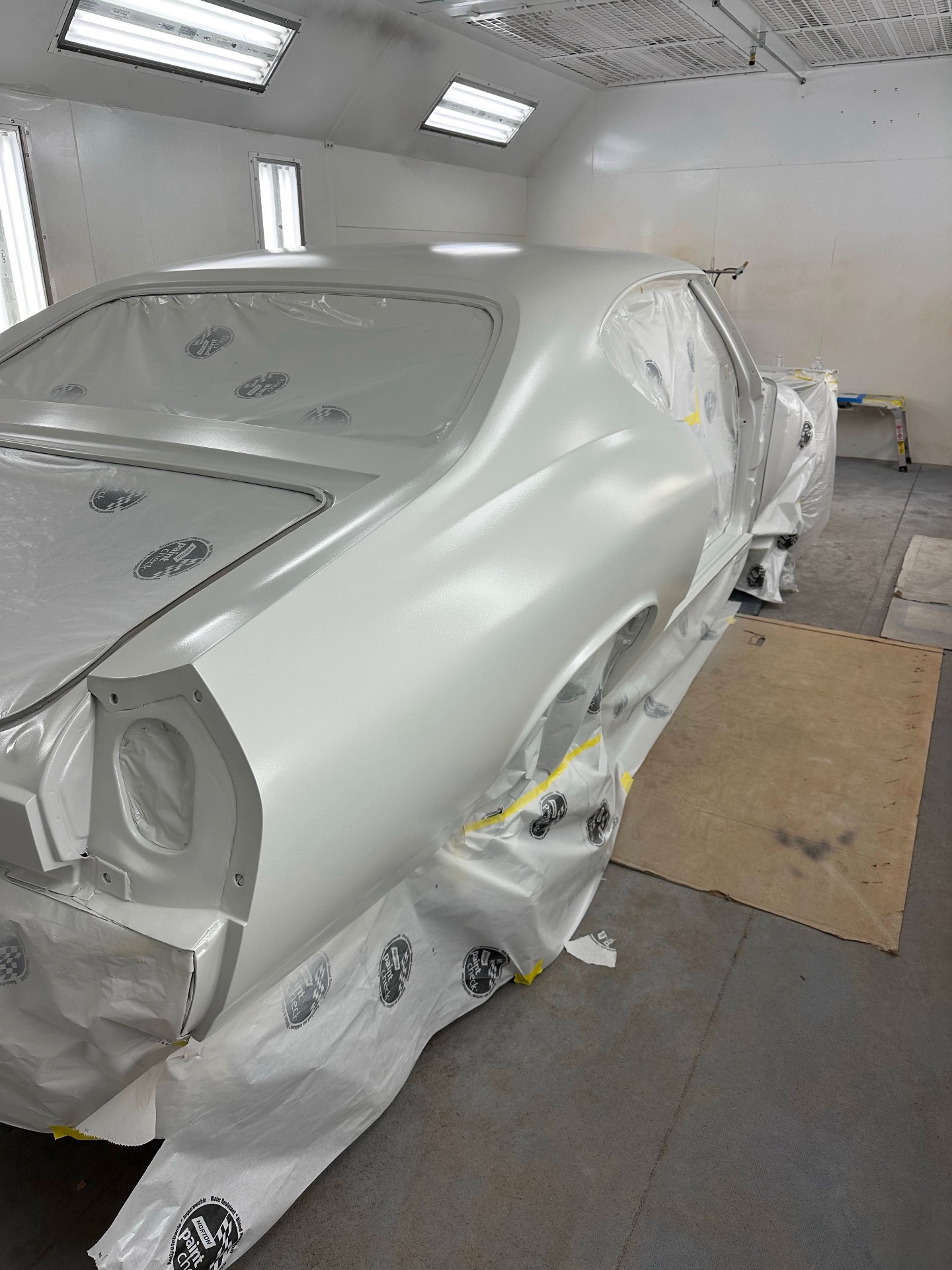 Rear three-quarter — pearl white base coats on the quarter and sail panel.