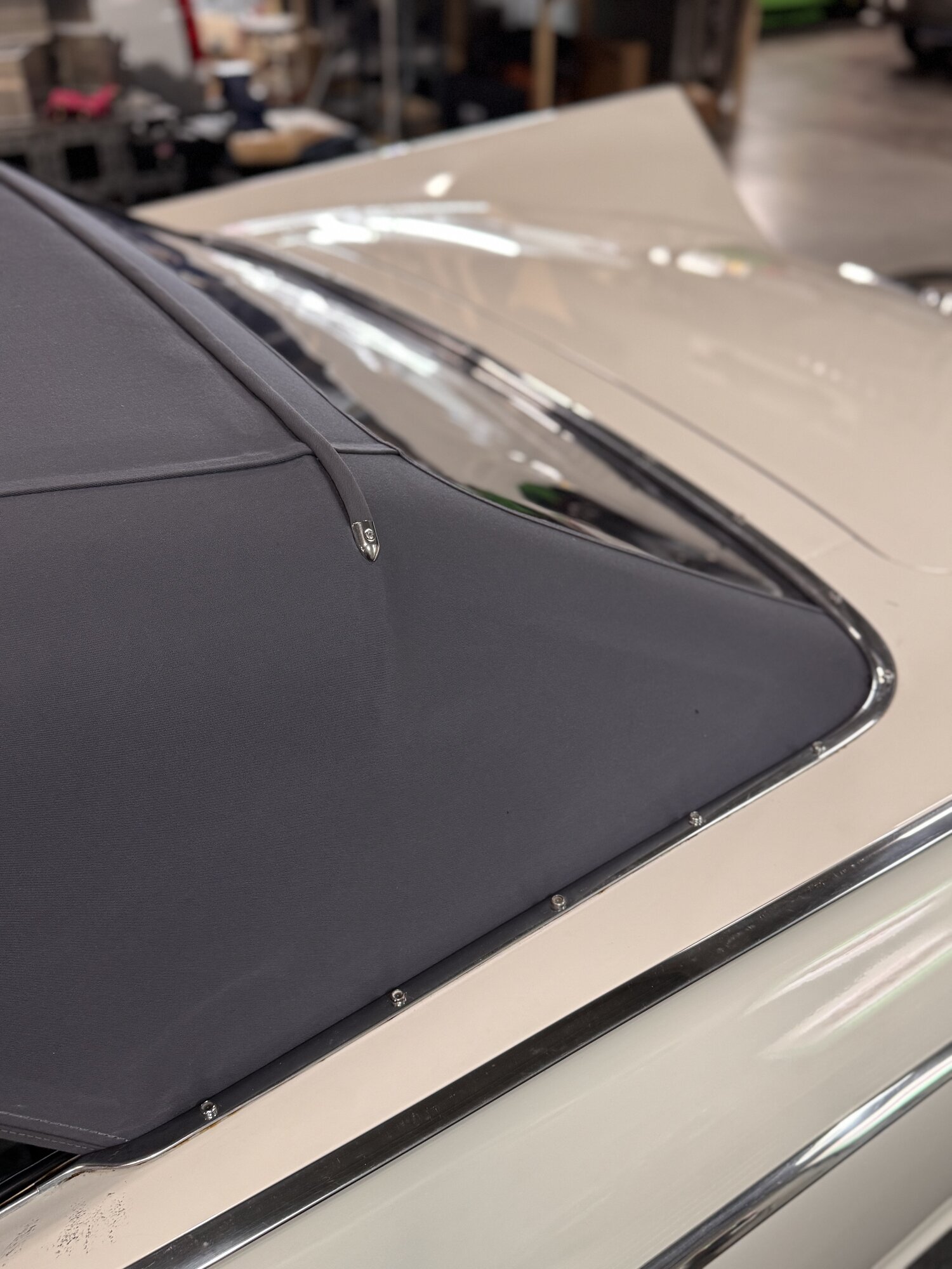 Close-up of the canvas seam, pull tab and polished trim where the top meets the body