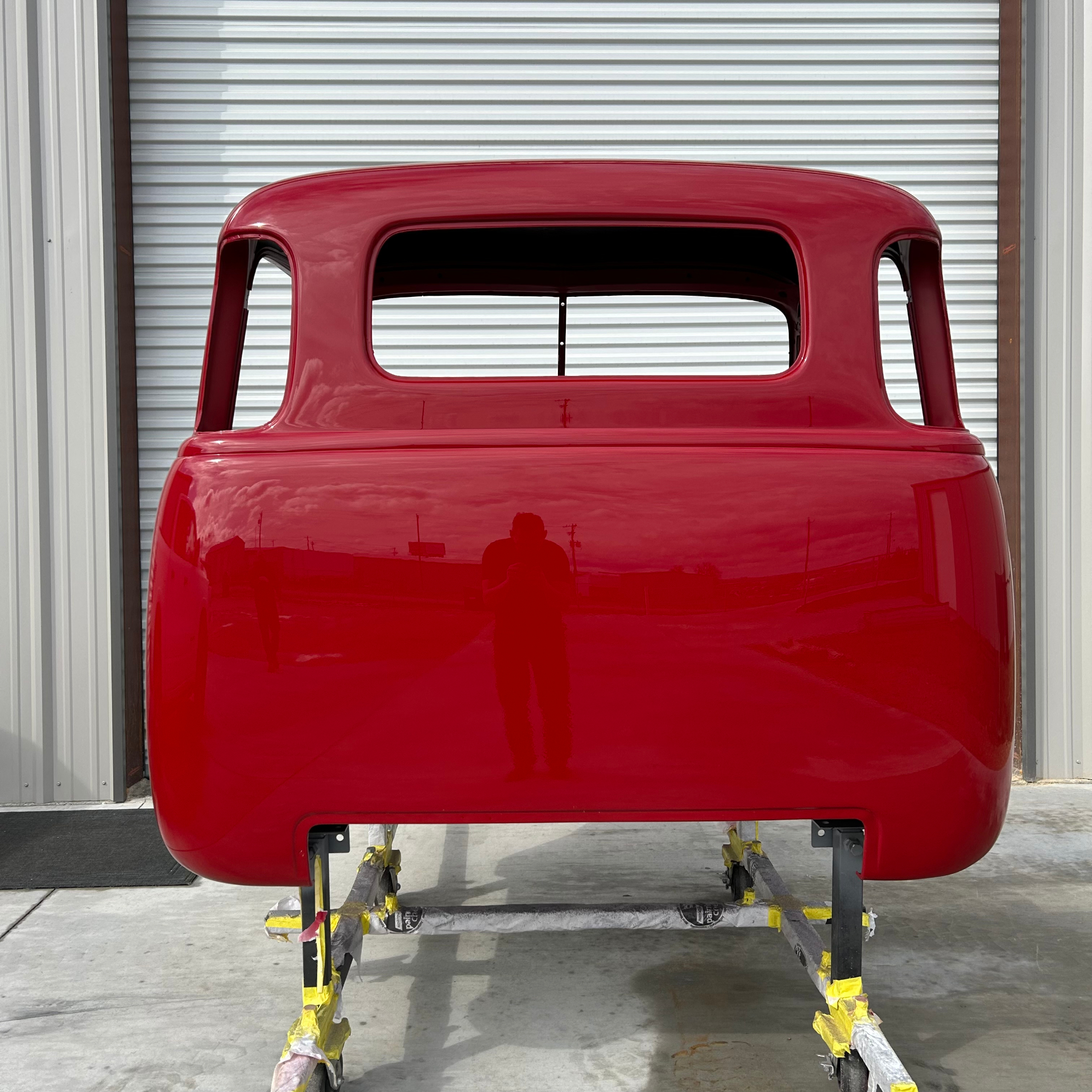 Back of the cab pulled out into daylight — mirror-flat clear over red paint.
