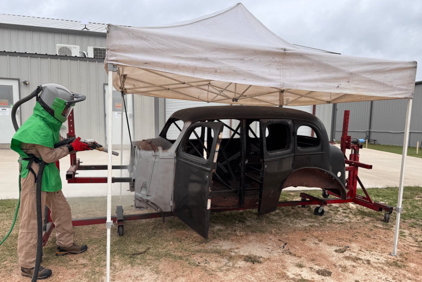 The sand blaster strips the body under the canopy.