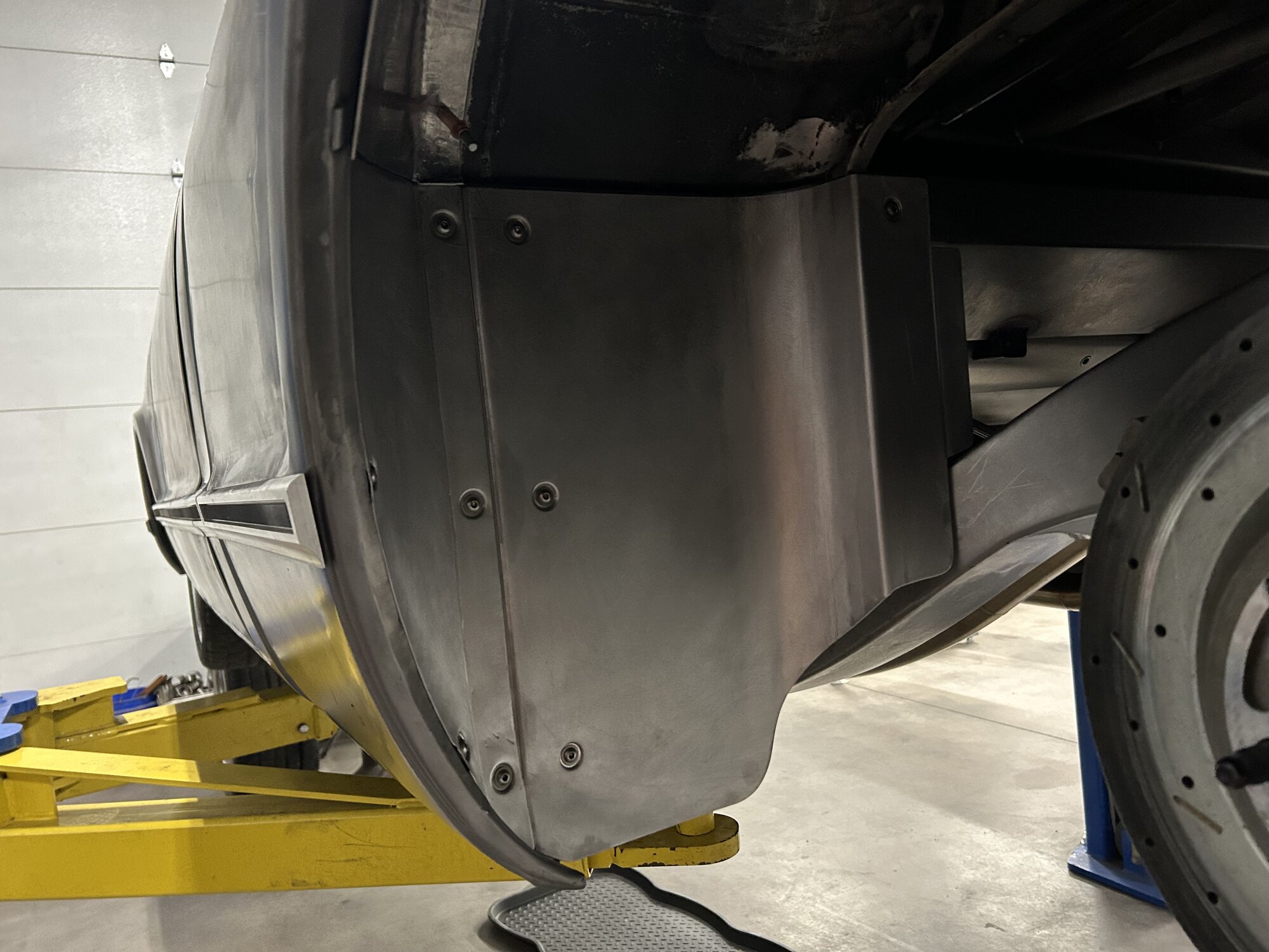 Hand-formed inner fender and panel work behind the front wheel.