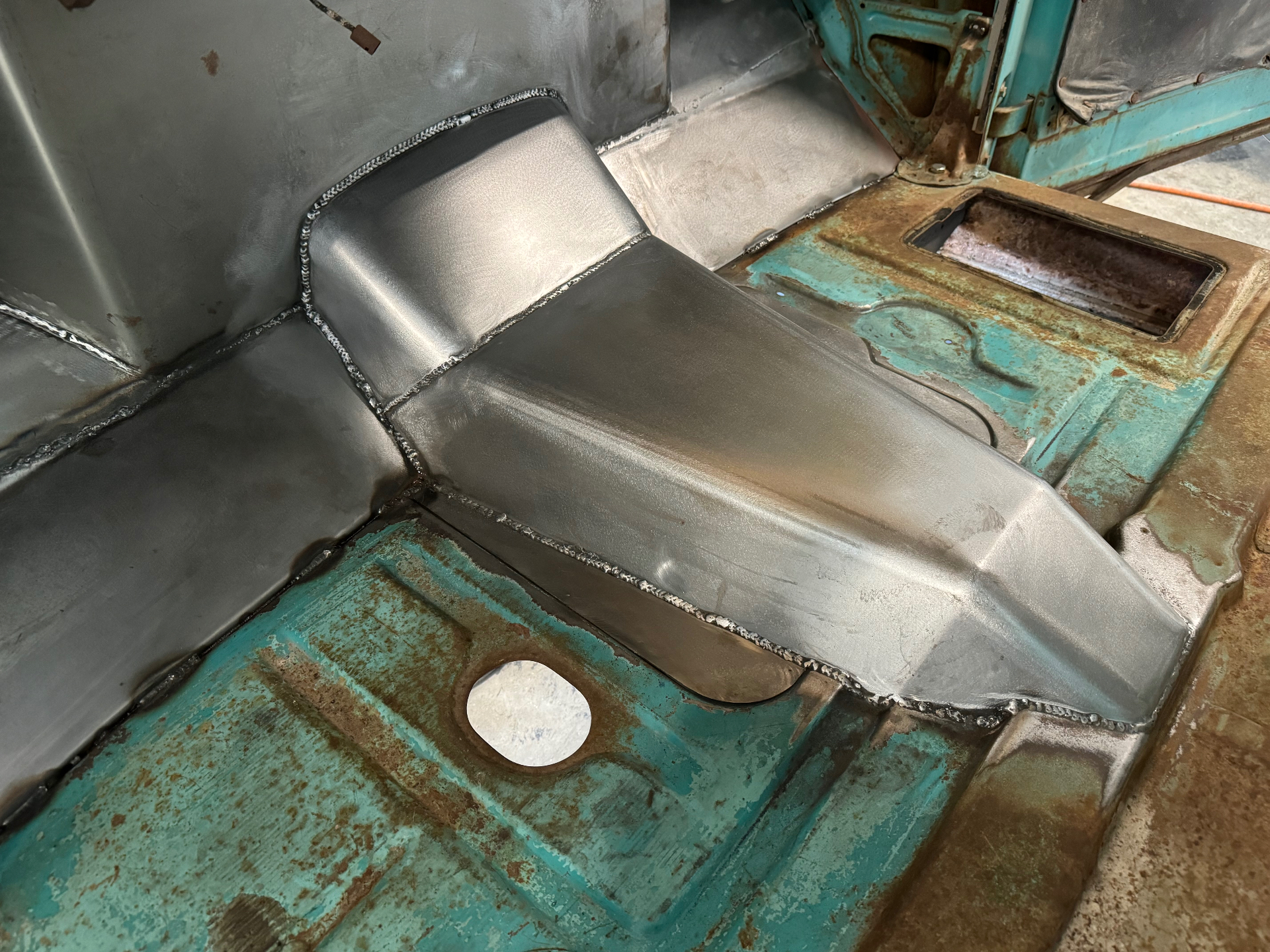 Driver side — clean transition where the new steel meets the old.