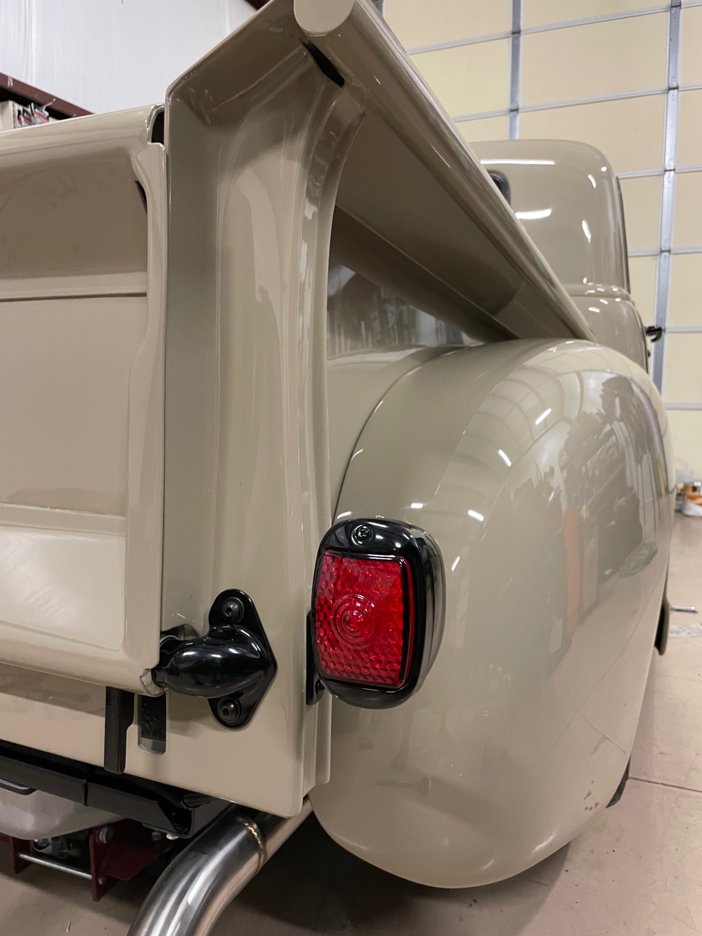 Rear corner buttoned up — custom stainless tailgate latch and tail light installed.