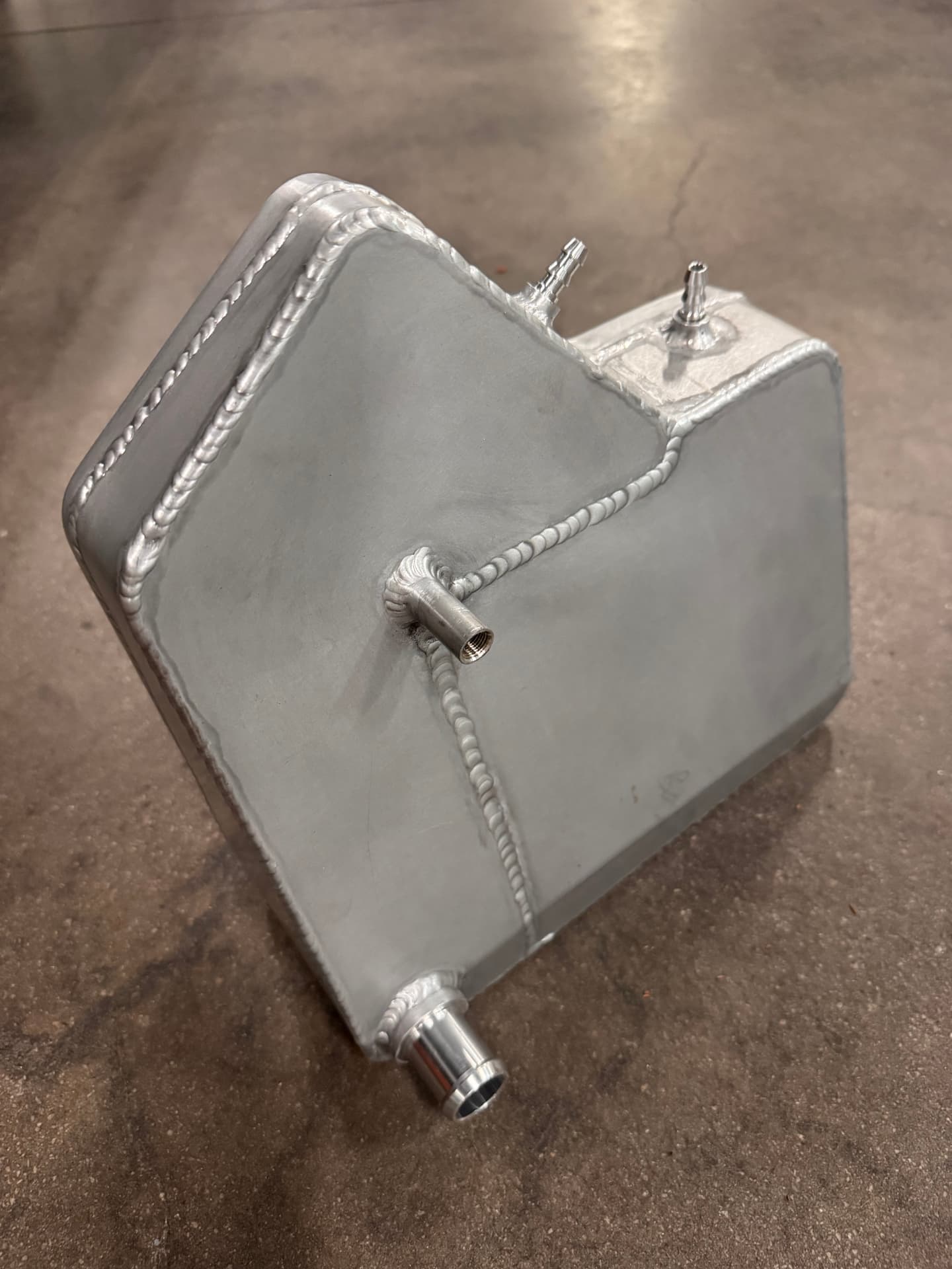 Welded hose fittings and bung on the back side of the tank.