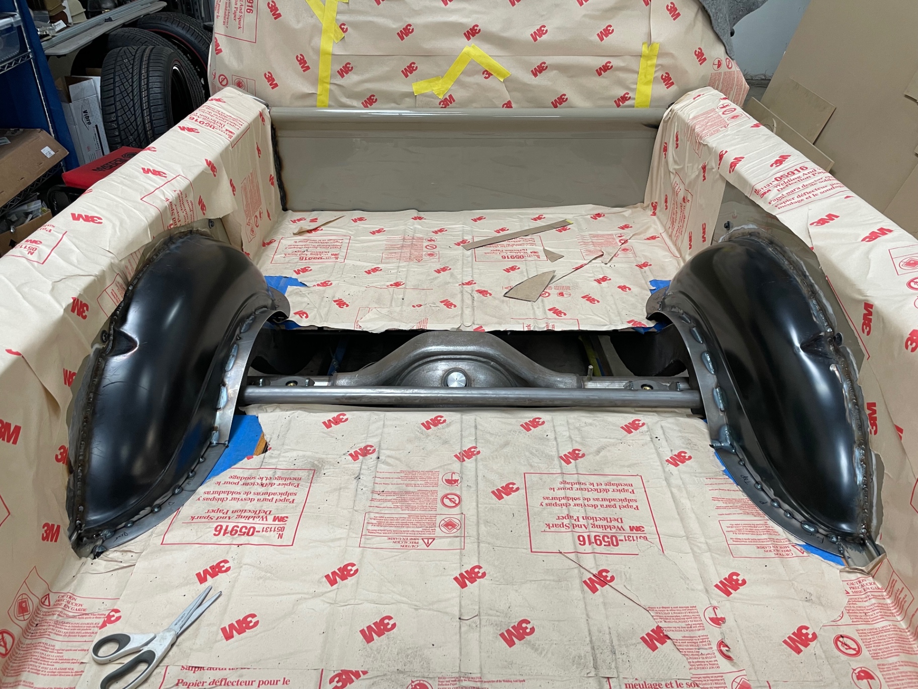 Bel Air inner wheel tubs stitched in — anti-spark paper masking the painted bed.