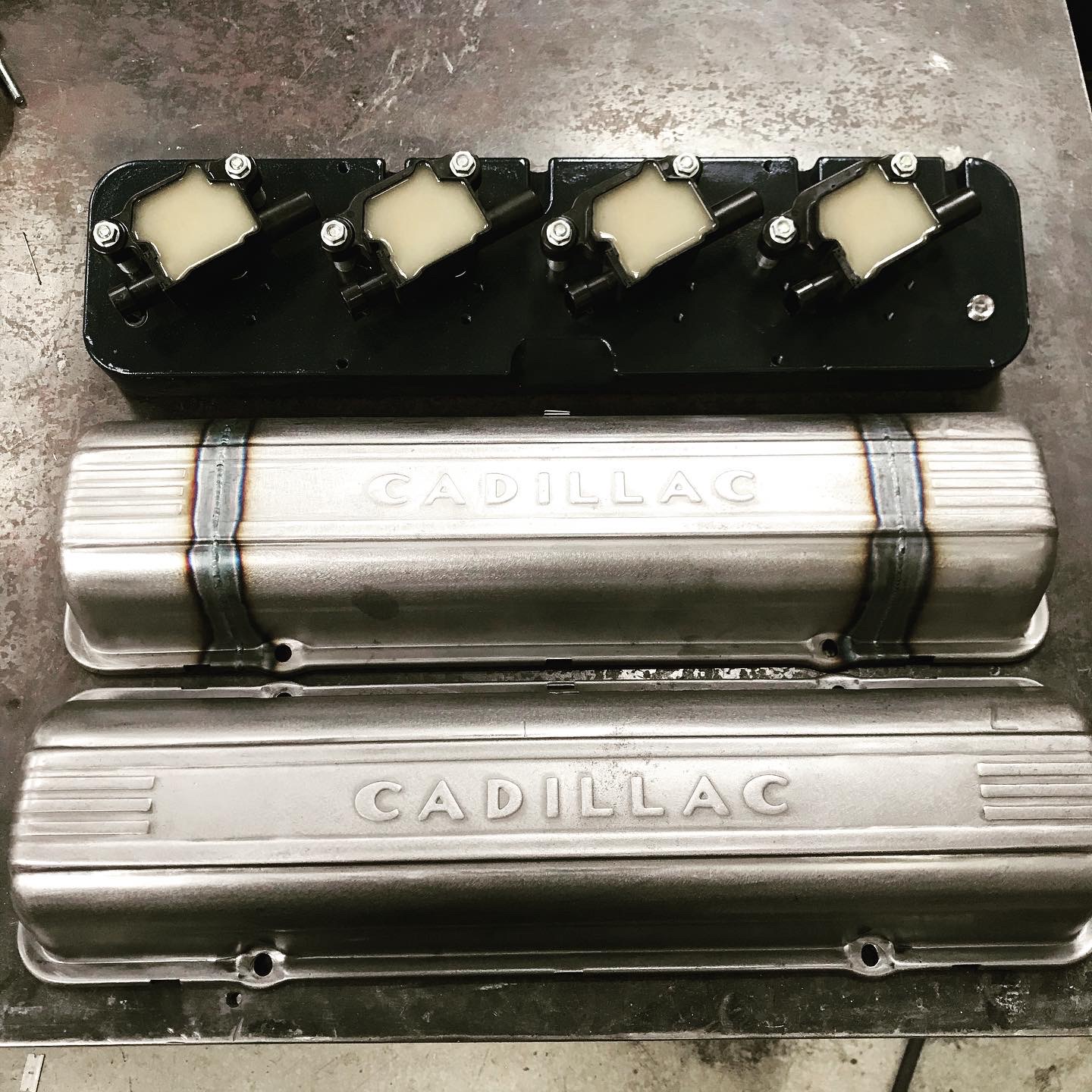 Modified Cadillac covers alongside the coil-pack bracket built to run them on an LS.