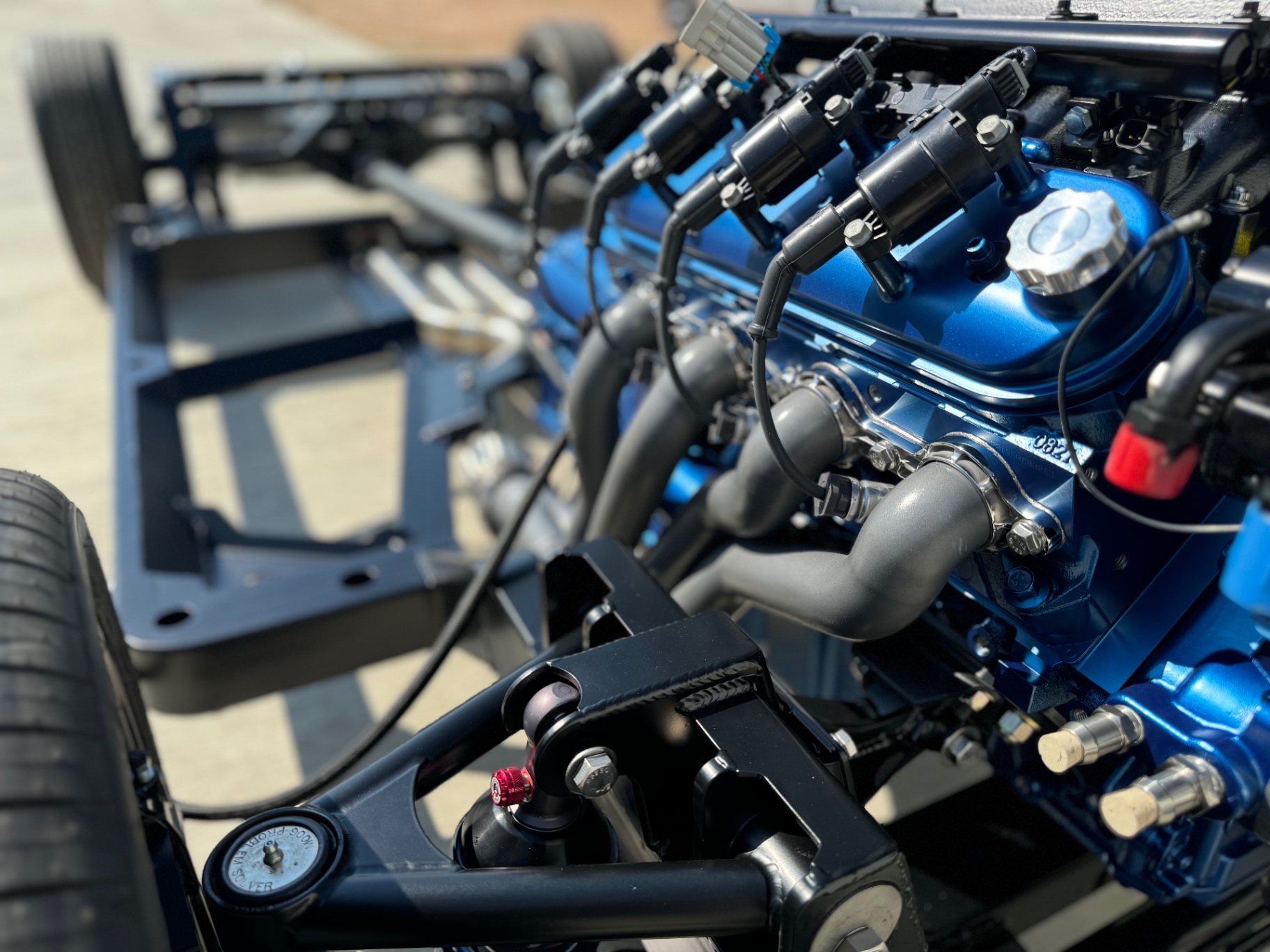 Valve cover and header detail — blue block against the black chassis.