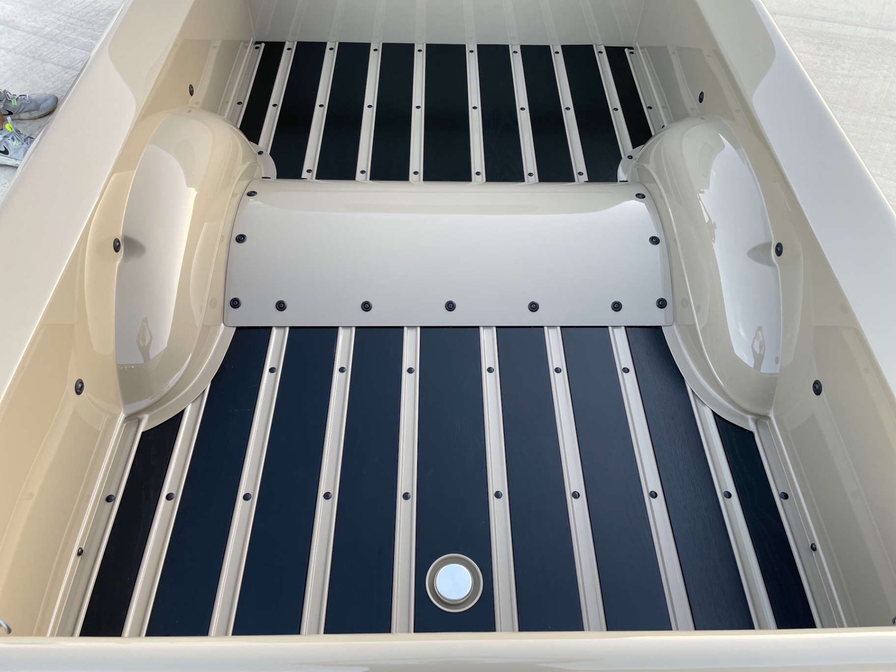 Bed floor overhead — symmetrical strips, tubs, and center driveshaft cover, polished fuel filler at the rear.