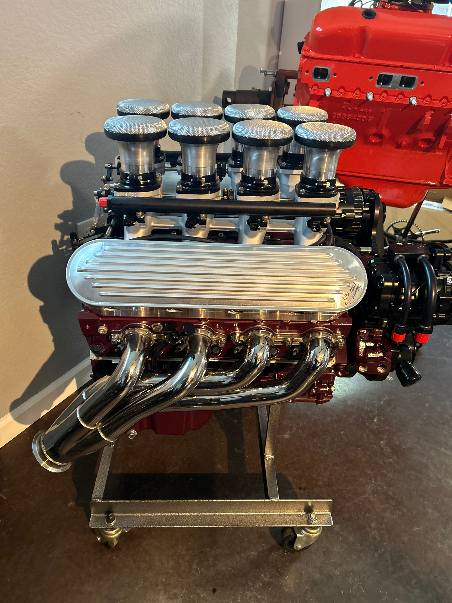 LS long-block with individual runner intake and polished headers on the stand.