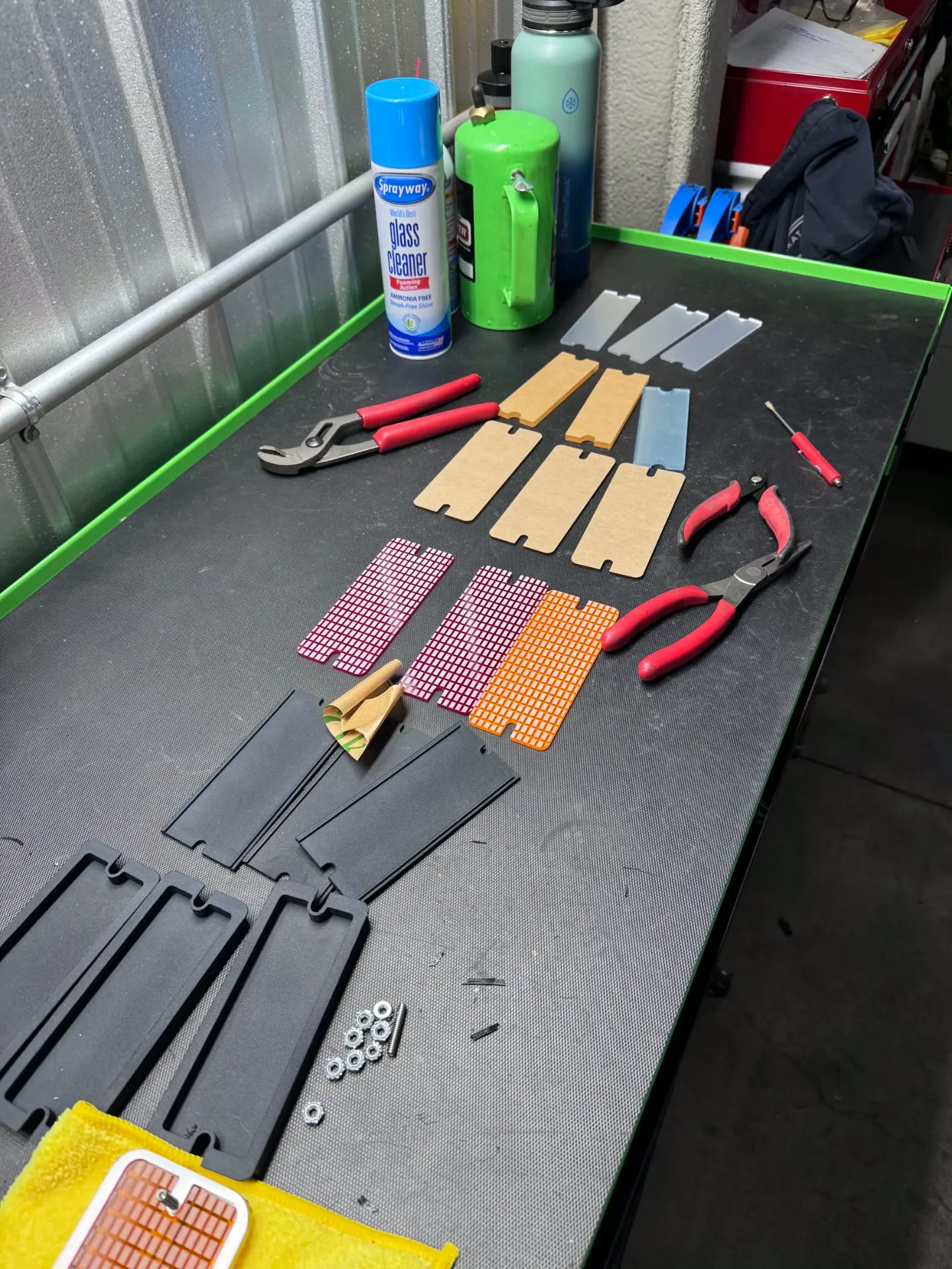 Lens blanks, diffusers, and printed housing parts laid out during assembly.