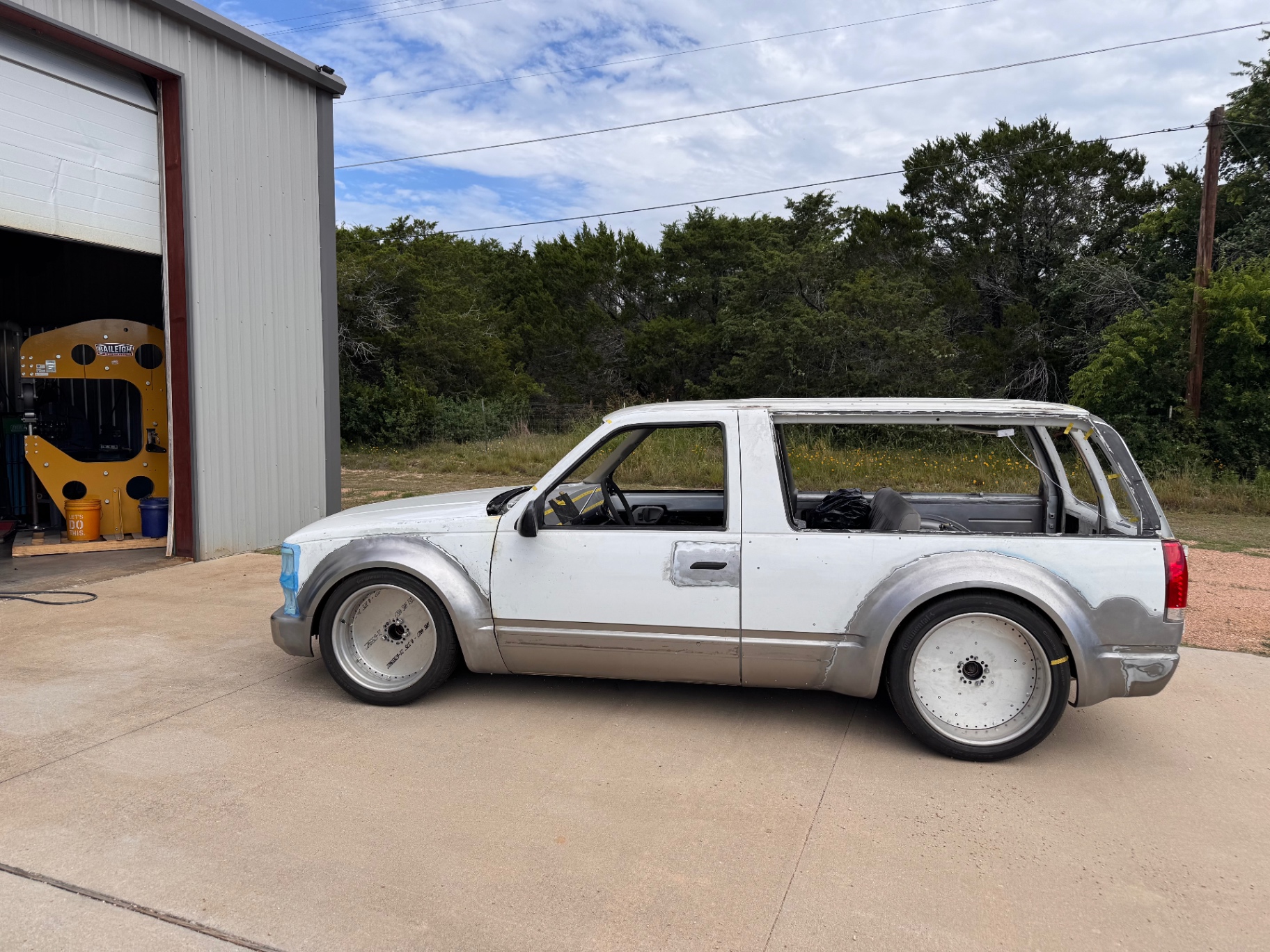Driver-side outside the shop — roller wheels only, final wheels TBD.