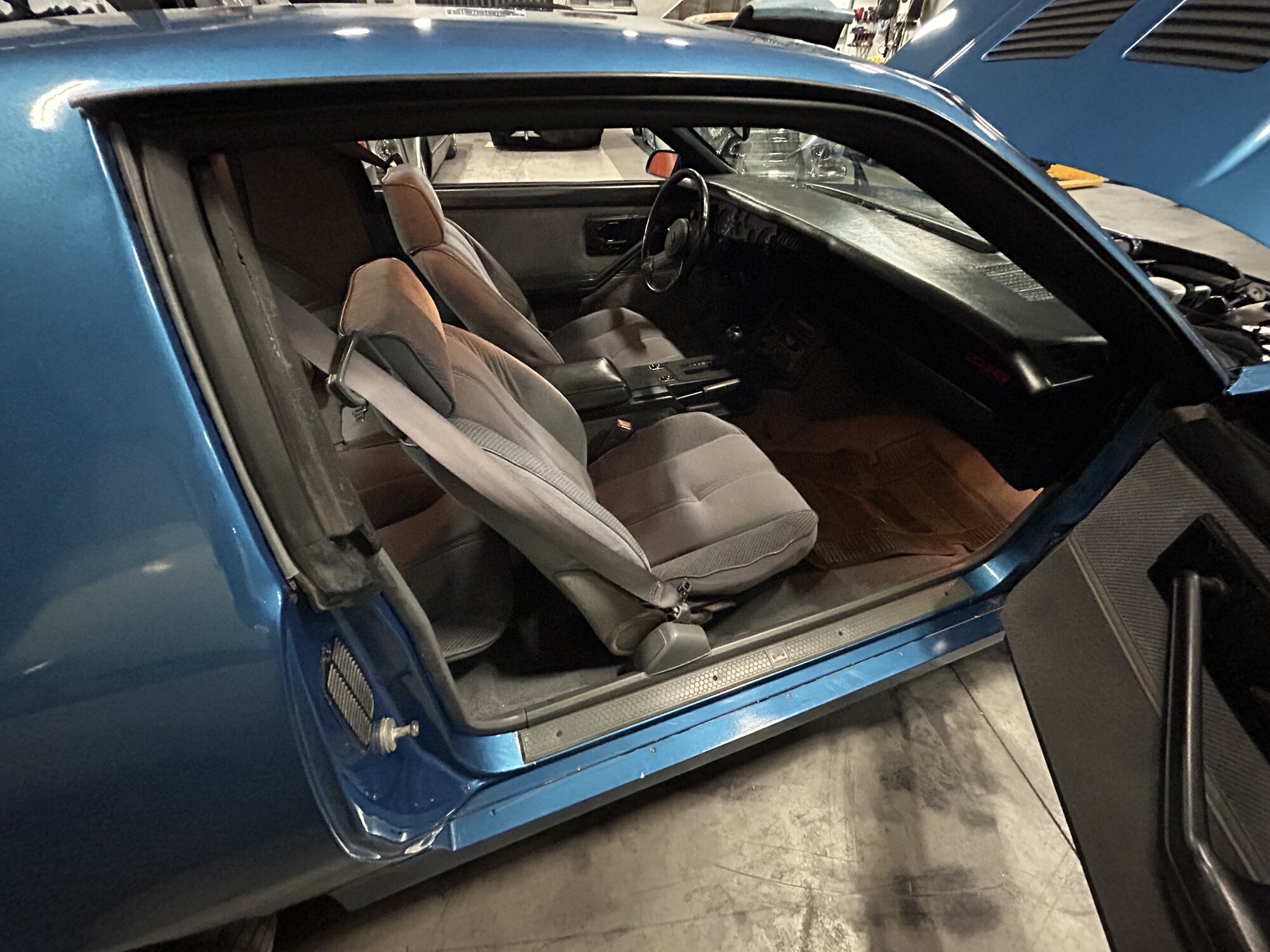 Driver's side — factory seats, console, and door sill trim all there.