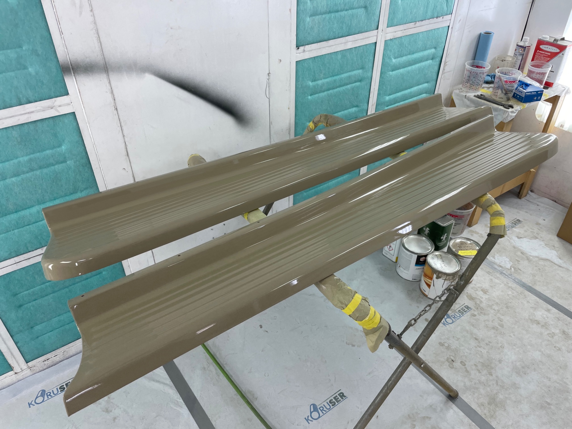 Running boards shot together — ribs picking up the booth light cleanly.