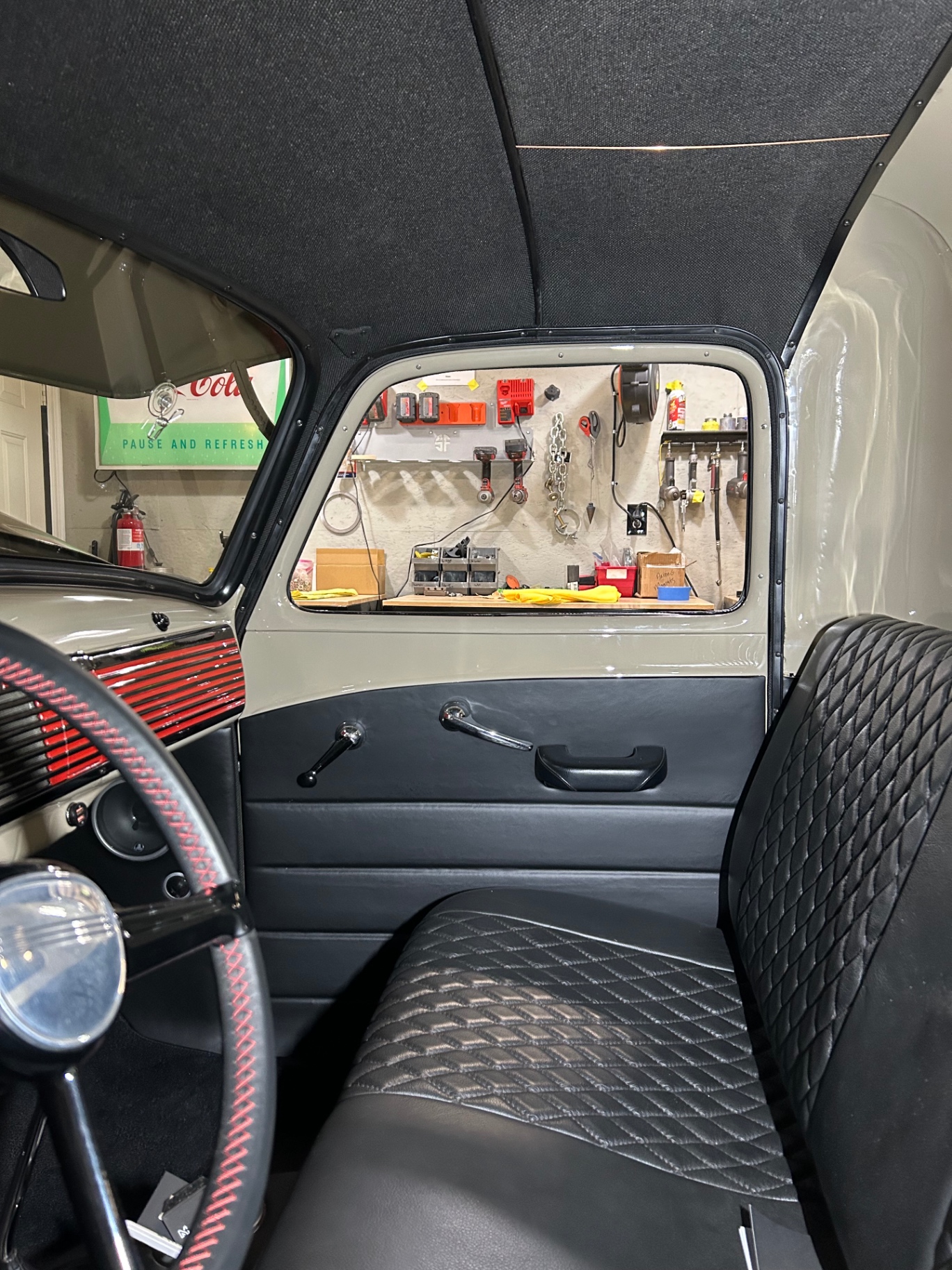 Interior looking across the bench — headliner, red-accented dash and wheel, new leather door panel through the window.