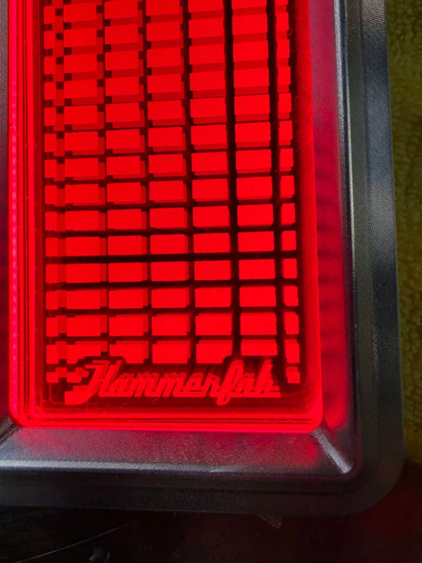 Close-up of the engraved pattern and script glowing evenly from the edge lighting.
