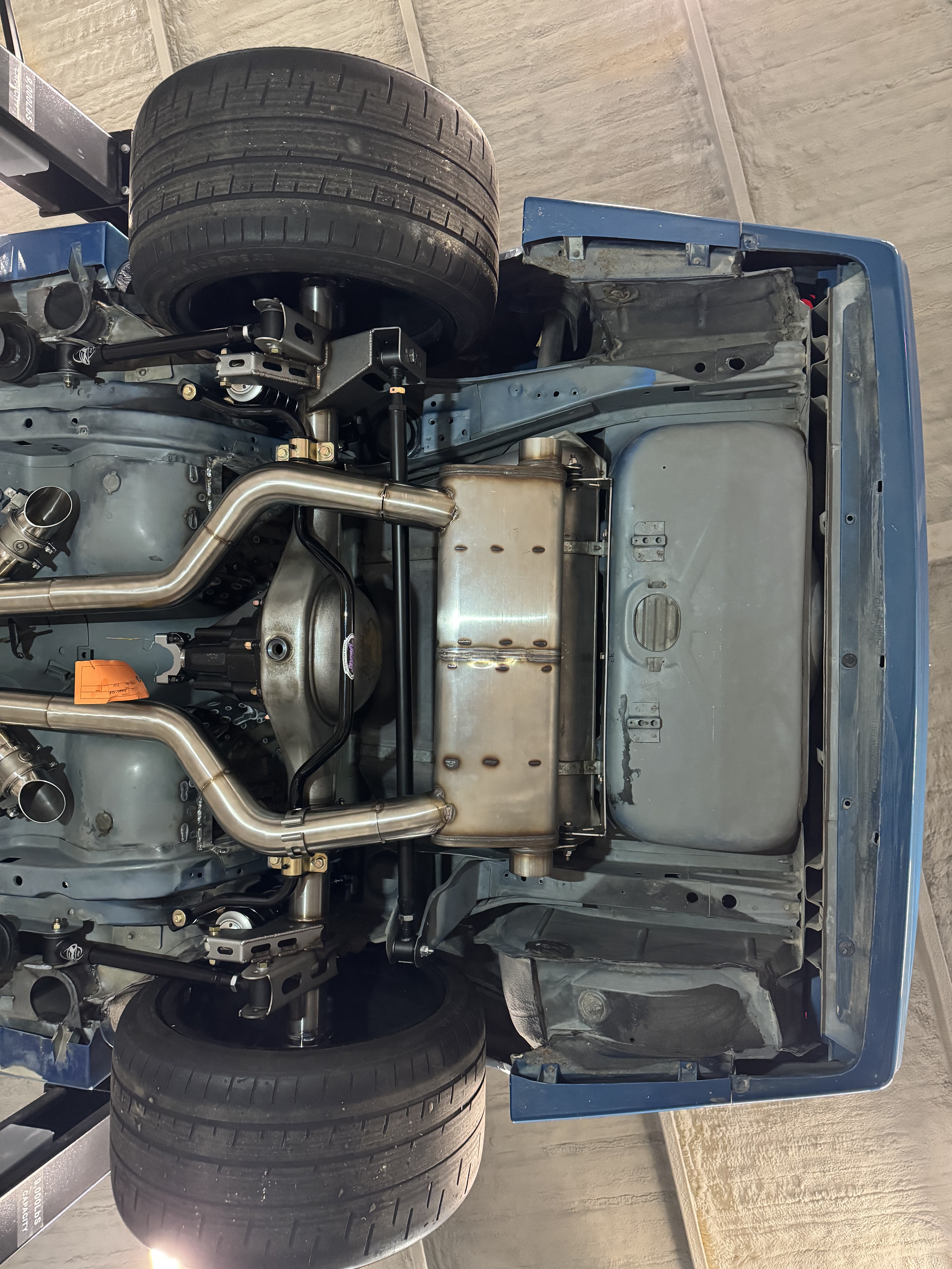 The custom mono muffler installed tightly behind the rear axle.