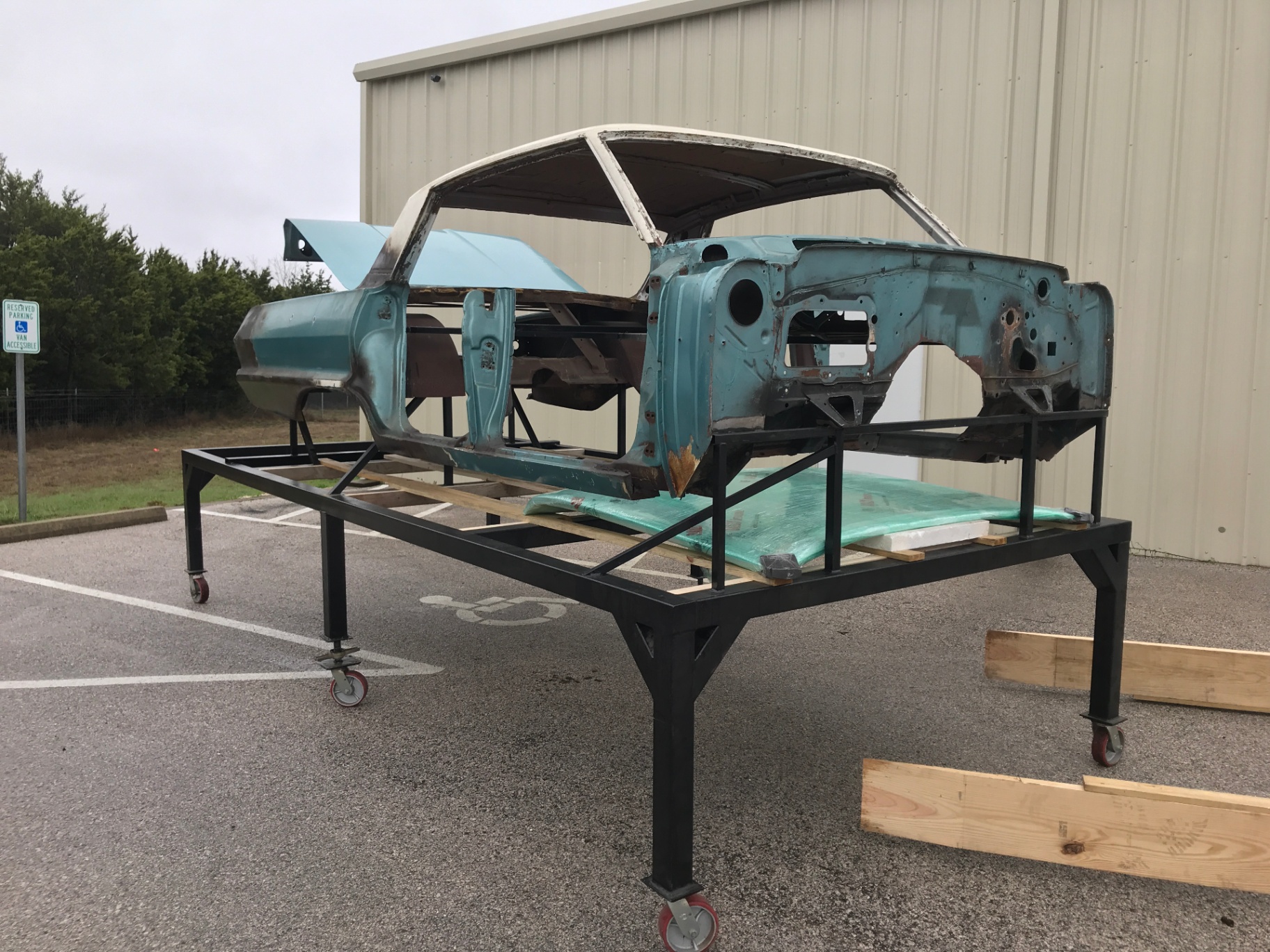 The 63 Impala on its build cart after teardown — original turquoise paint still visible.