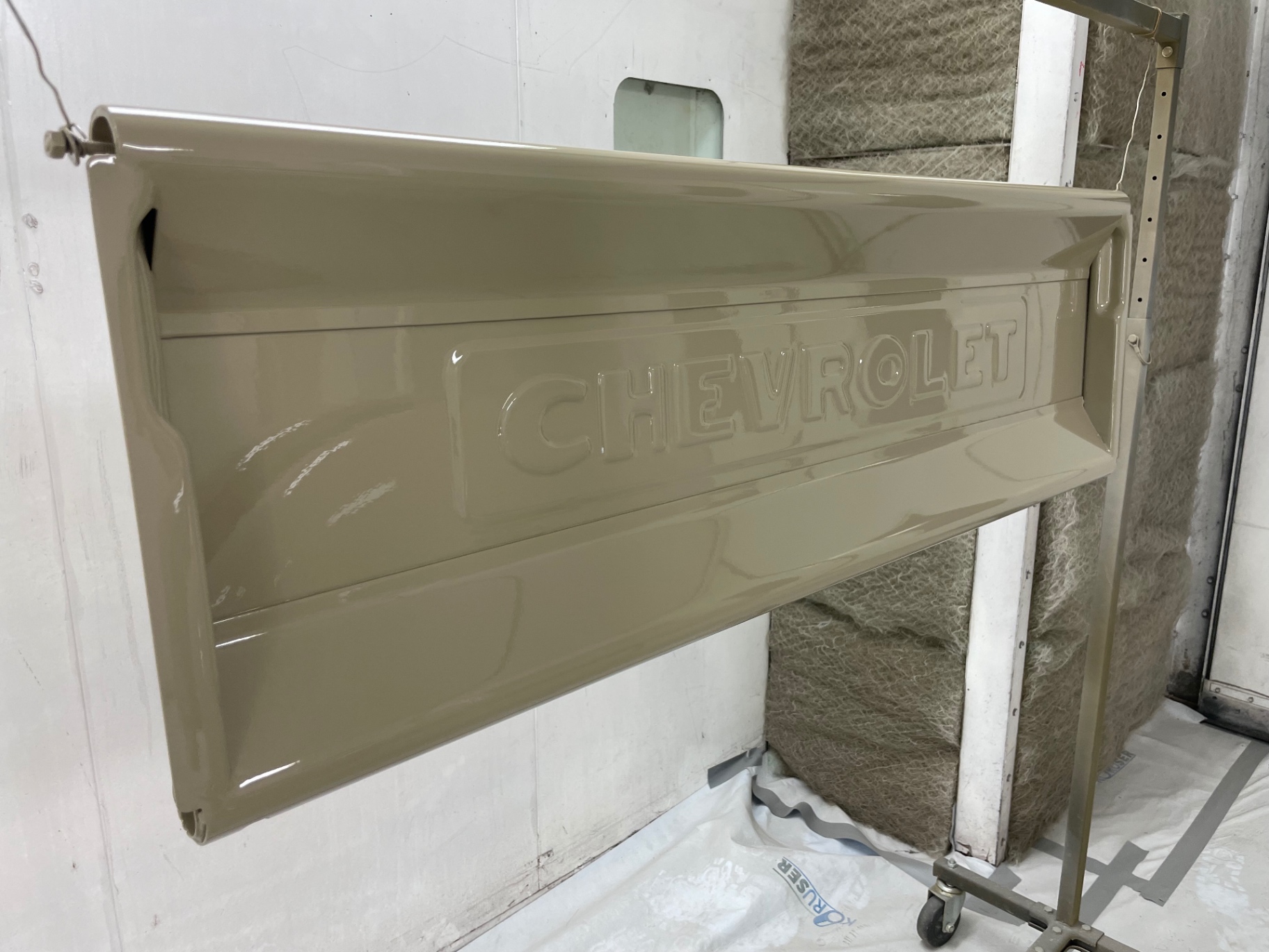Tailgate with the stamped Chevrolet script, laid down in the final tan.
