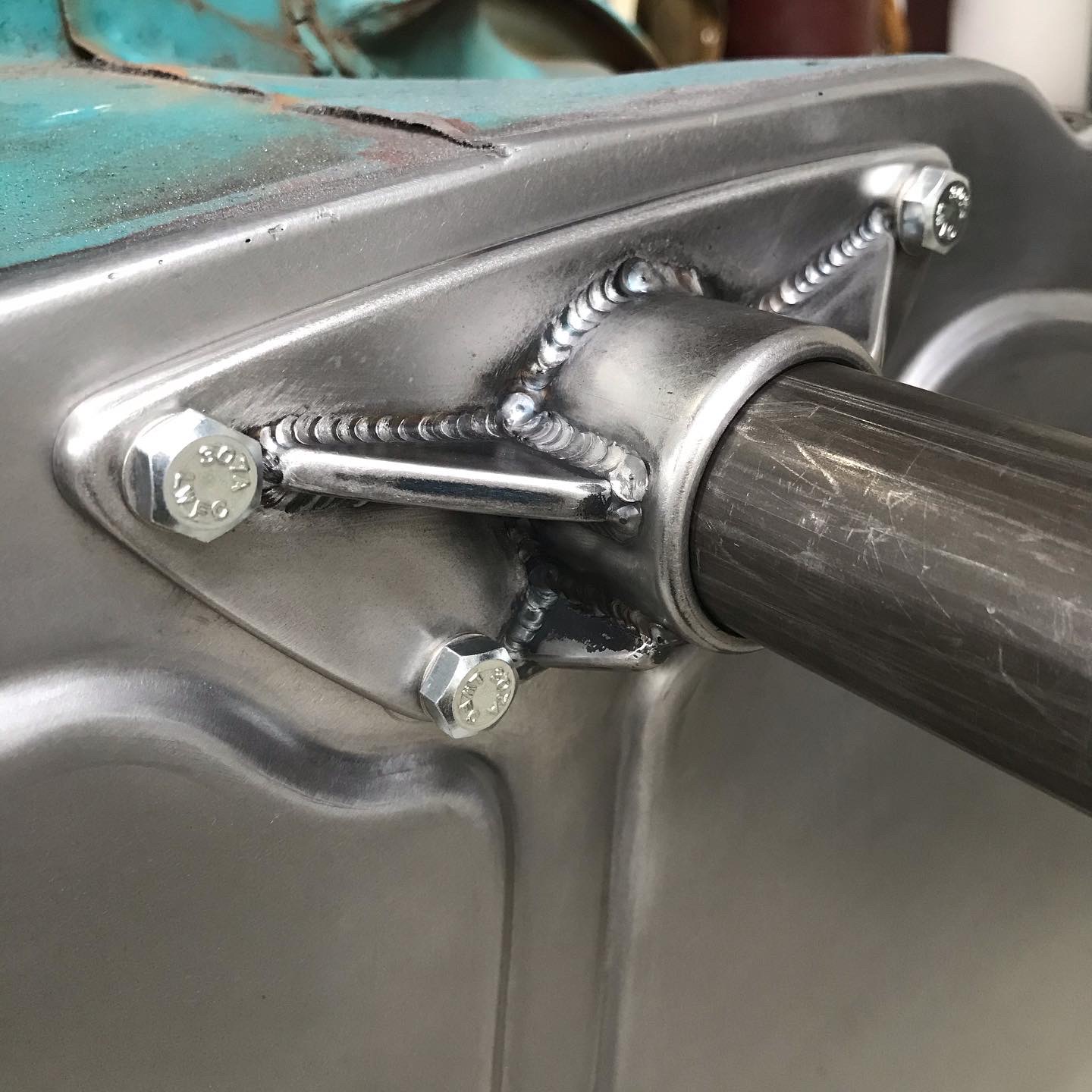 Column pass-through bung — TIG'd in with gussets for stiffness.