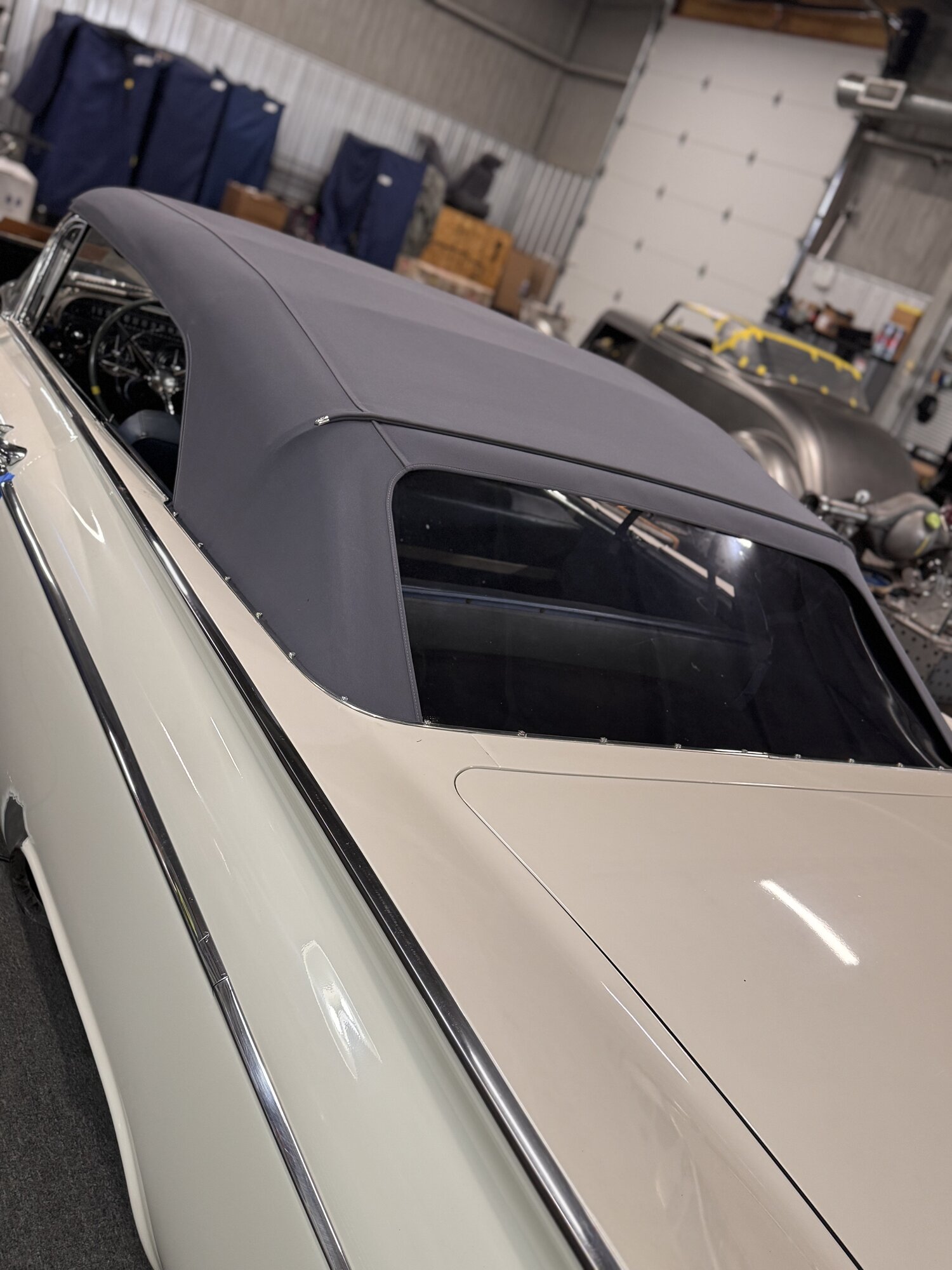 Rear three-quarter — quarter window and canvas seam lines settled into the body