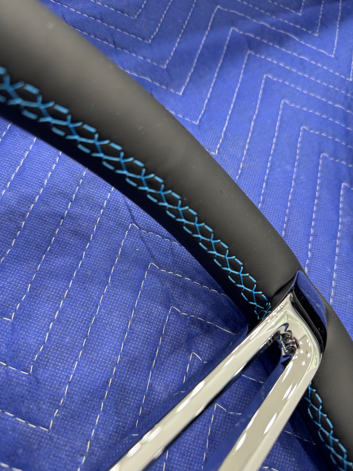Ironworks billet steering wheel — hand-stitched leather with blue cross-stitch detail.