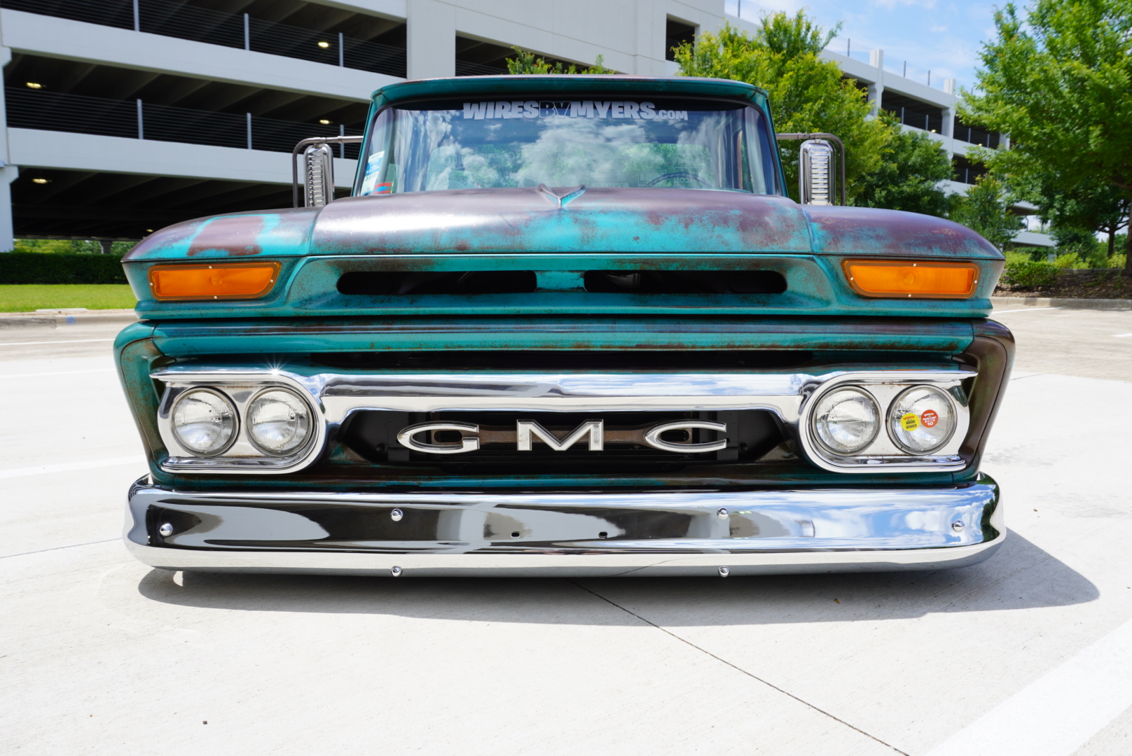 Head-on — chrome bumper, GMC grille, and hood patina.