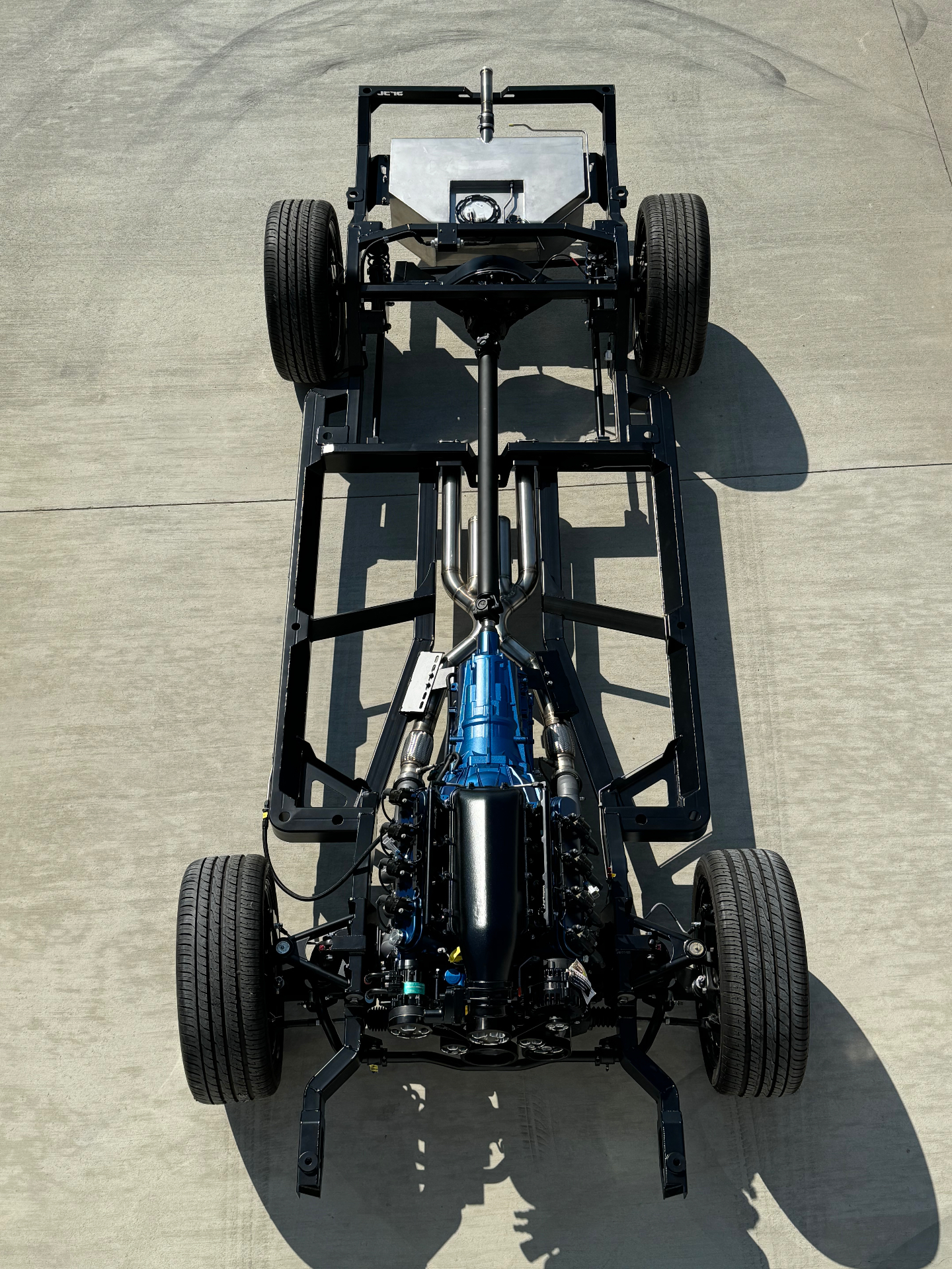 Rear view — stainless gas tank and custom stainless exhaust routed through the SPEC frame.