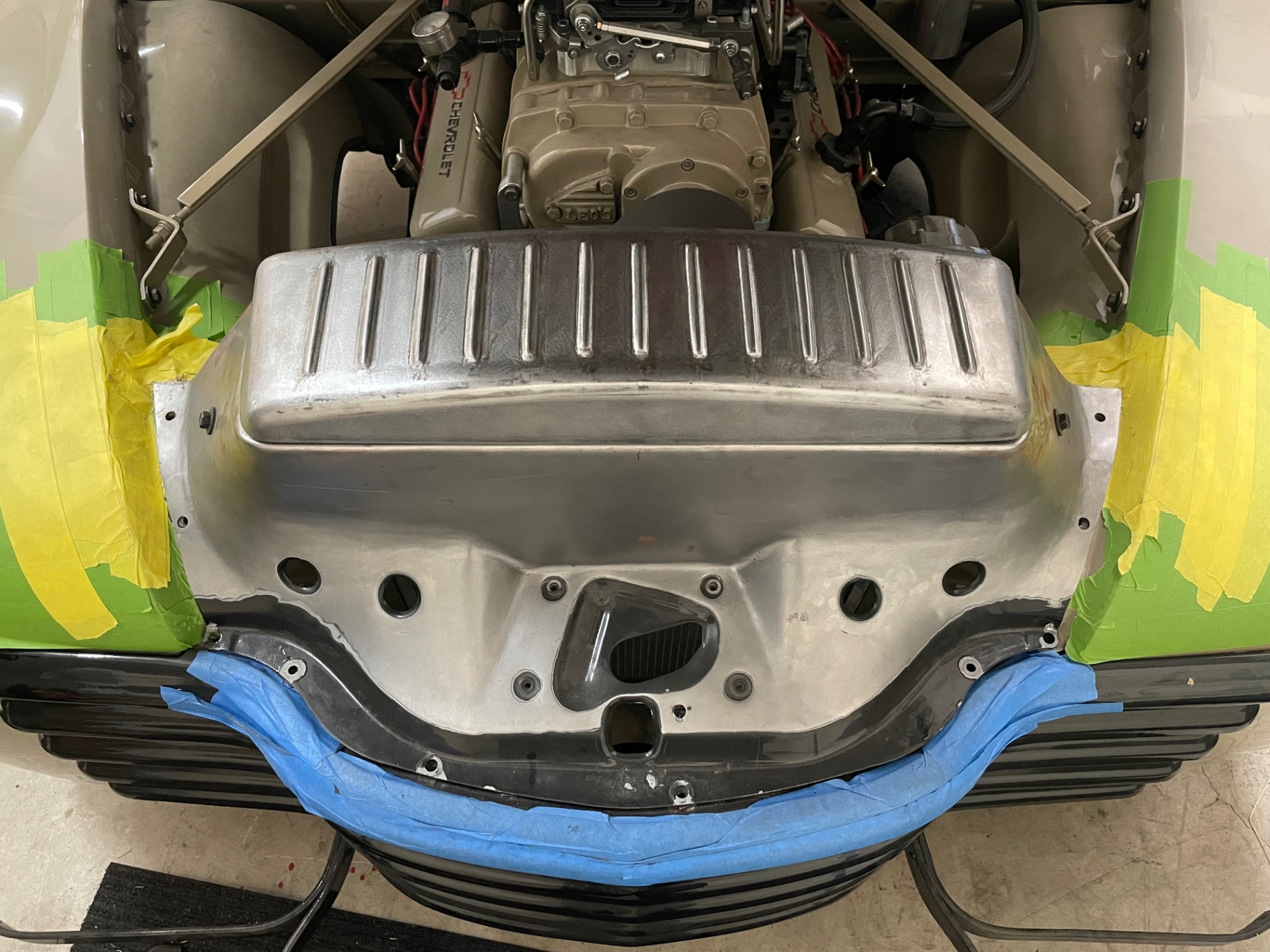 Fabricated radiator cover fit-up — bridging grille to firewall over the small block.