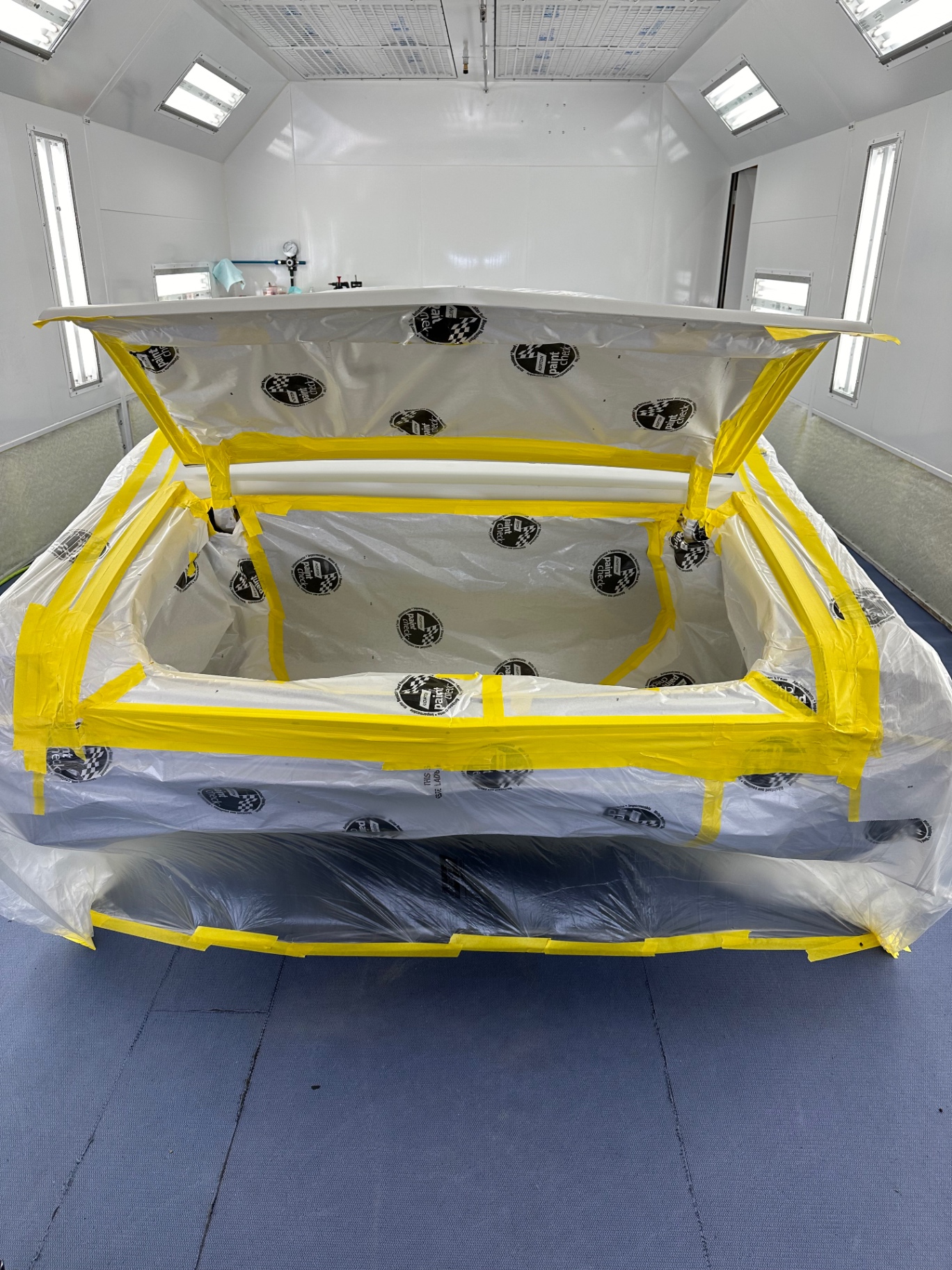 Trunk jamb painted and masked off — clean edges before the exterior stripes.