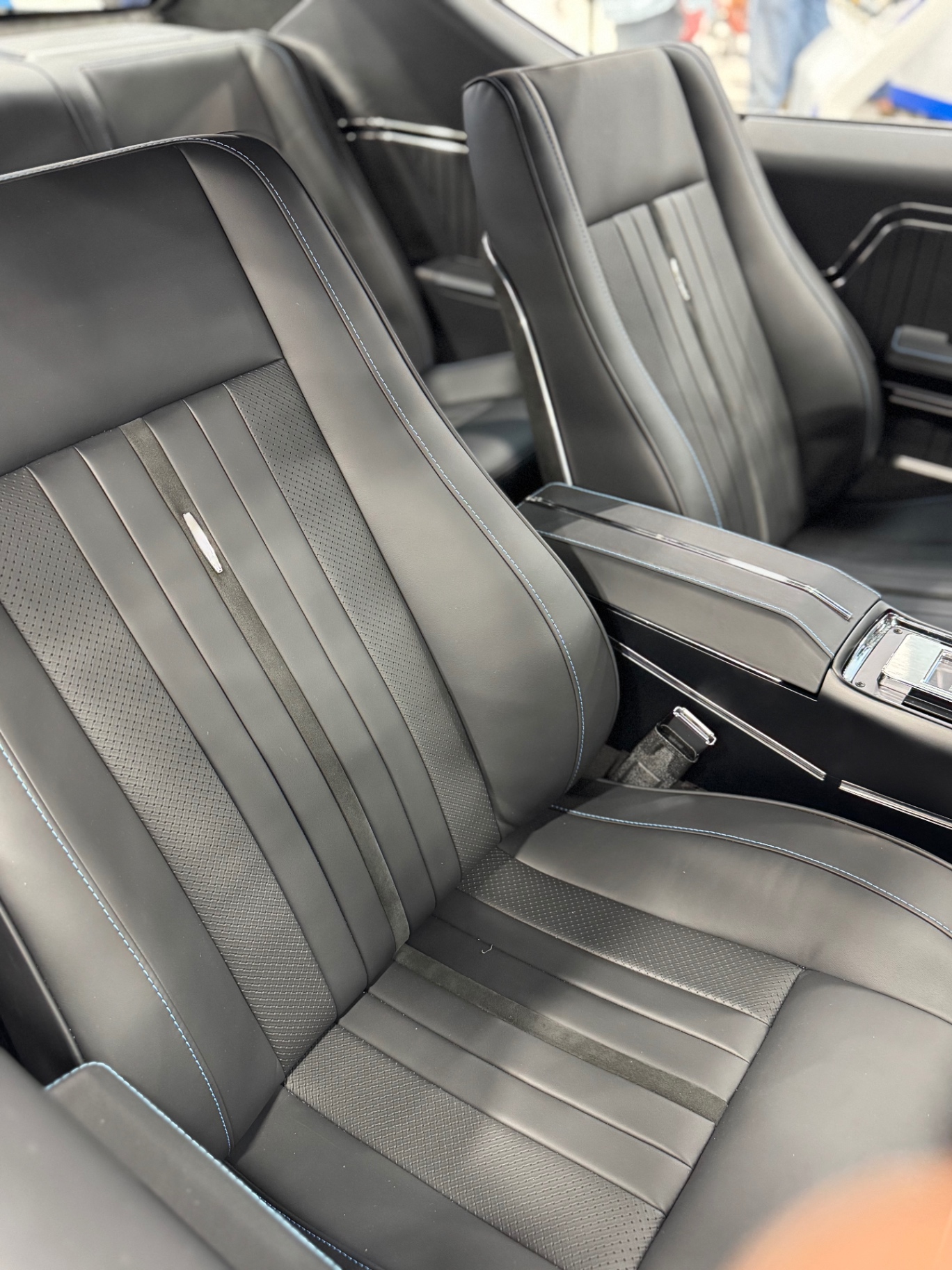 Front seat detail — Moore & Giles leather with contrast blue stitching.