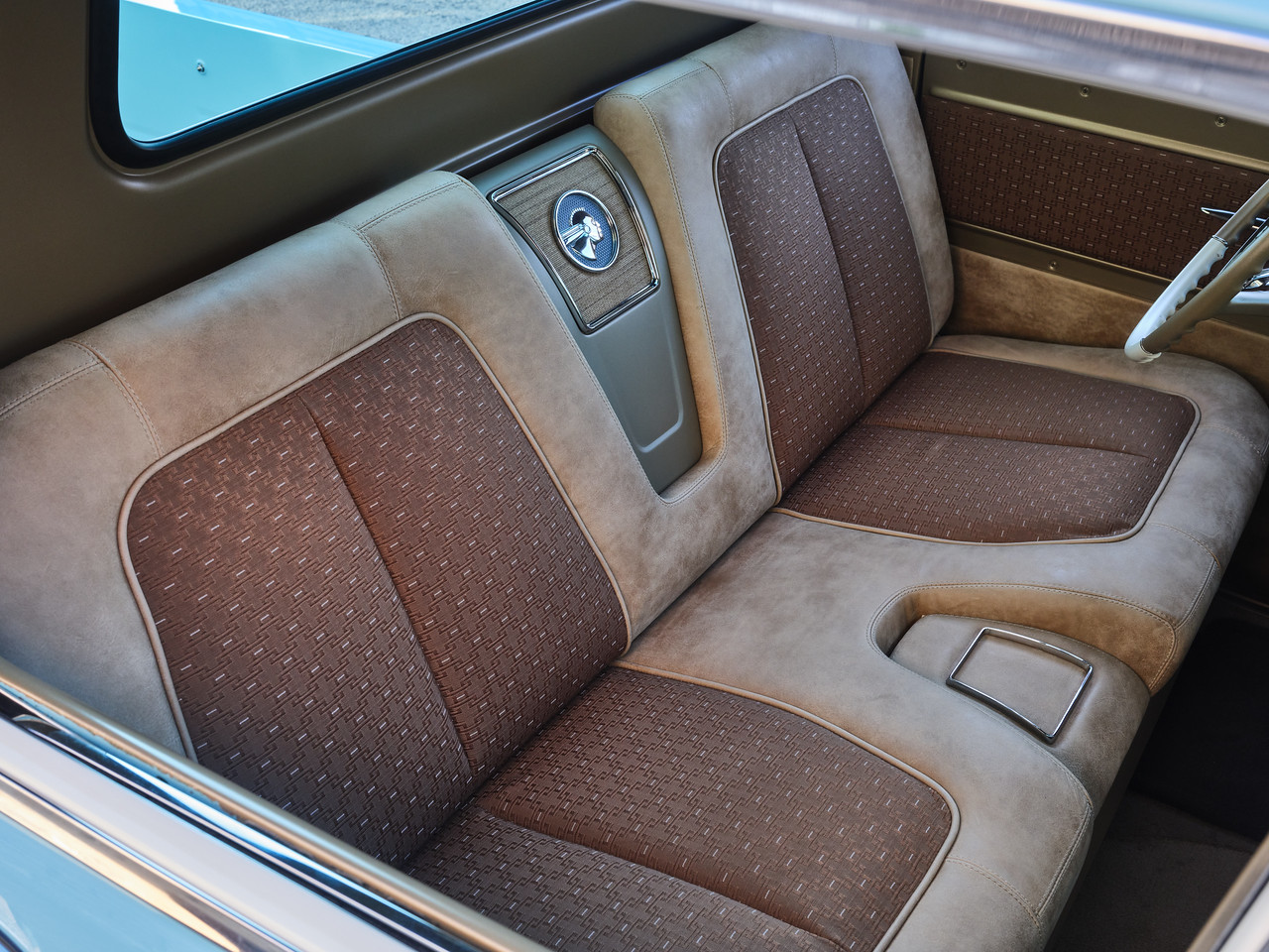 Bench seat detail — Jay Schluter foam and stitch, dual-tone leather with NOS 1955 Bel Air fabric inserts and Pontiac-tribute emblem.