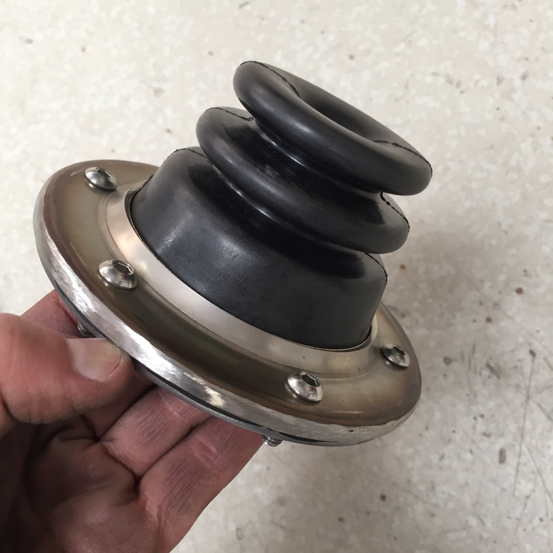 Stainless bezel and aluminum base with the boot installed — ready to bolt to the tunnel.