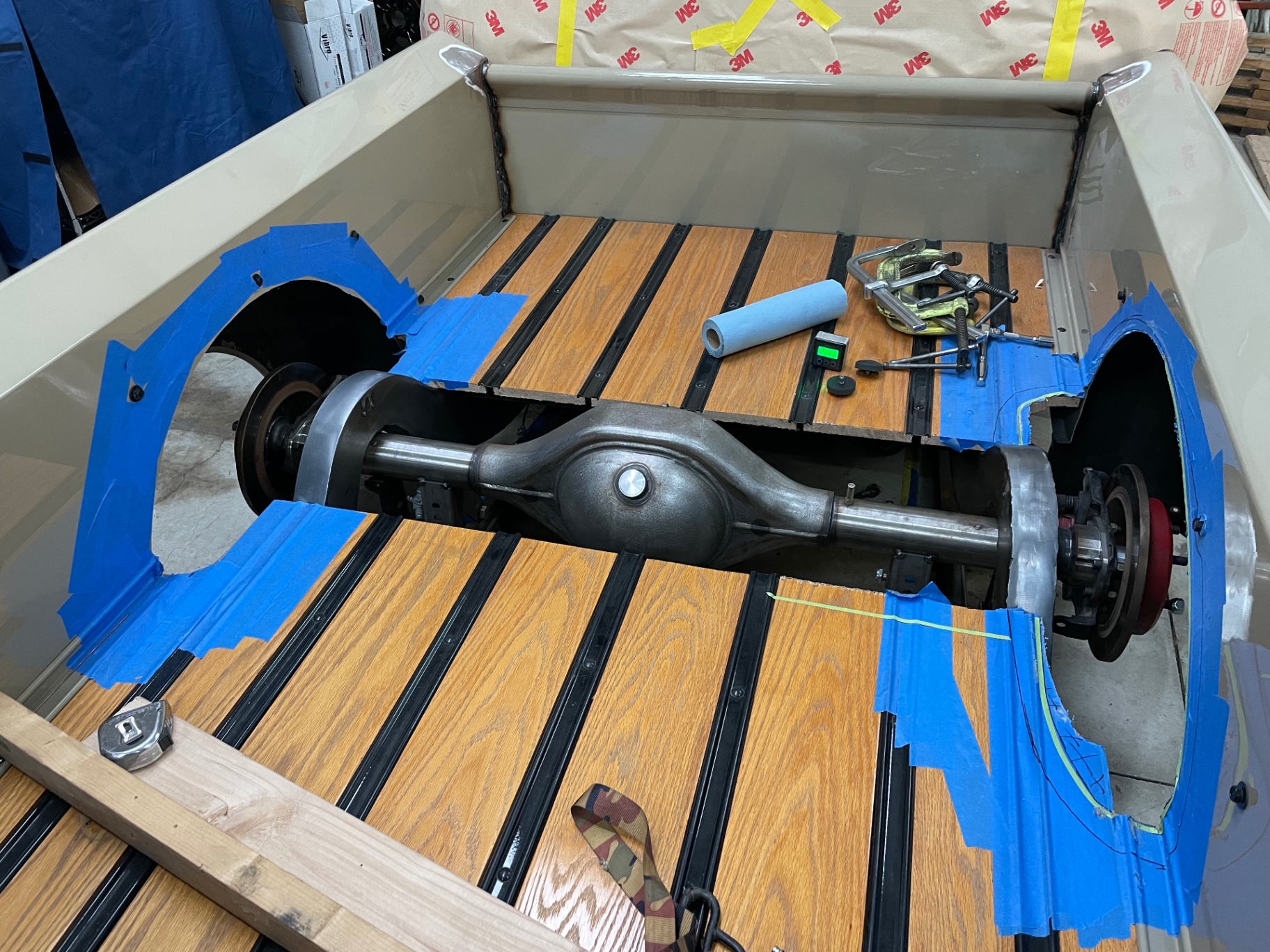 Bed floor cut for axle clearance — rear end dropped in for final fitment.