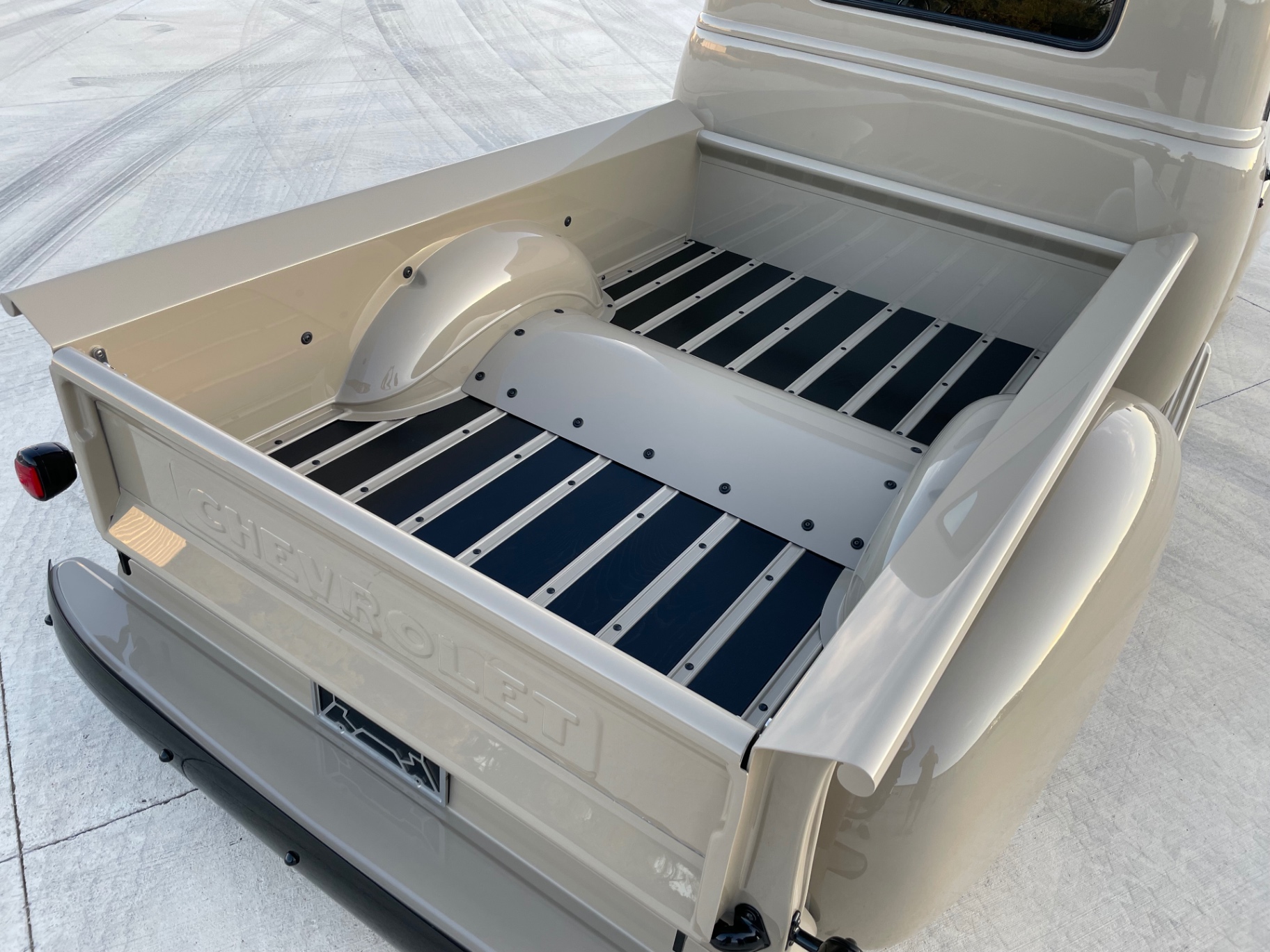 Bed assembled — painted strips over black wood planks, Bel Air tubs in body color, stainless latches on the tailgate.