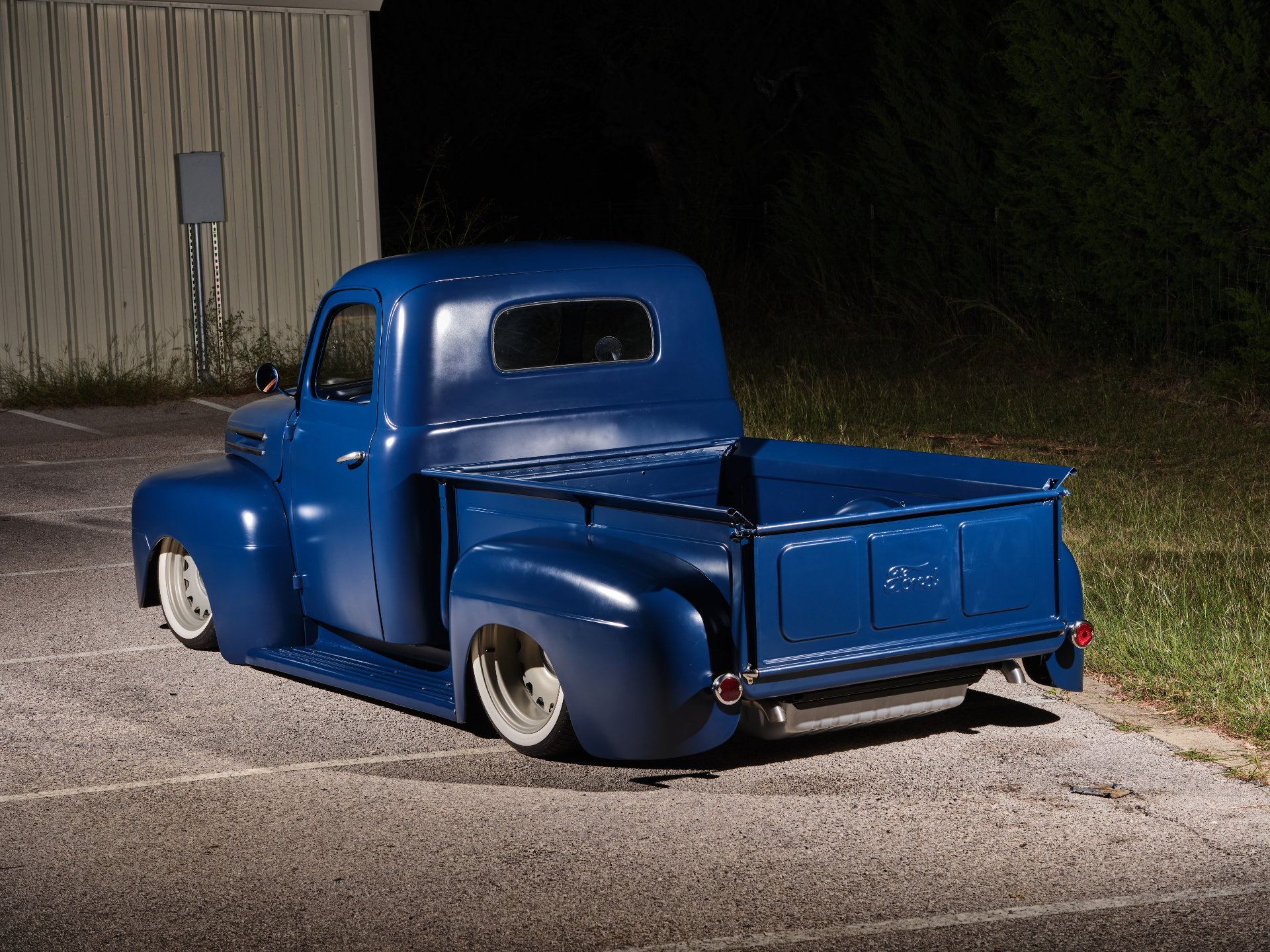 Rear three-quarter — Ford tailgate, laid-out stance, and tucked exhaust exit.