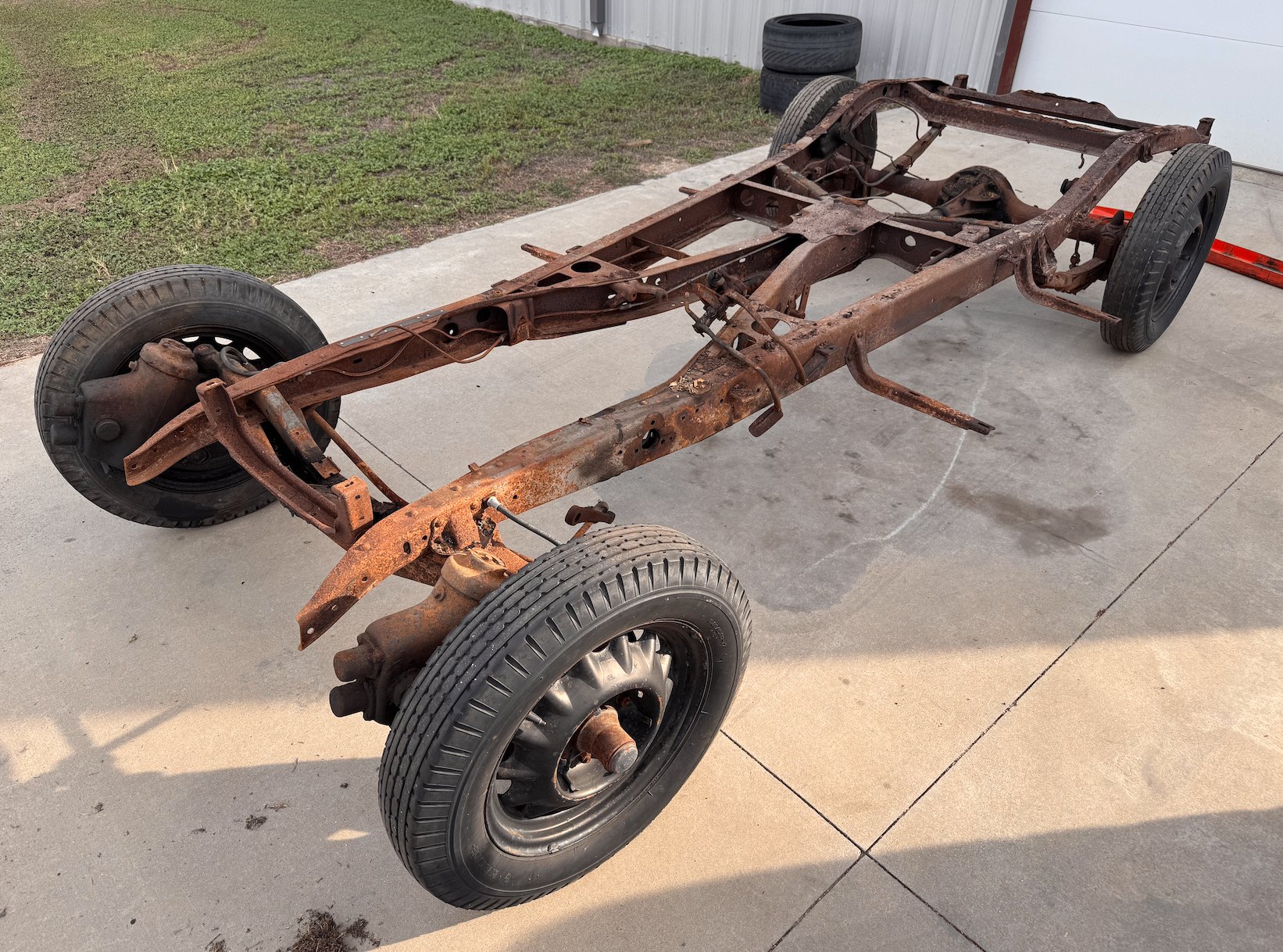 The original chassis, headed out — a new Roadster Shop chassis takes its place.