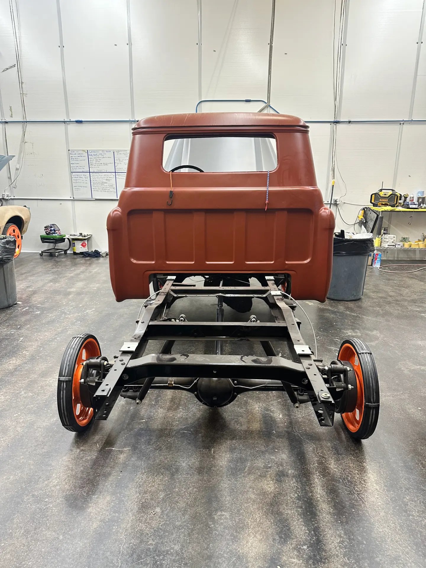 Cab and chassis mocked up in the shop, orange steelies under it.