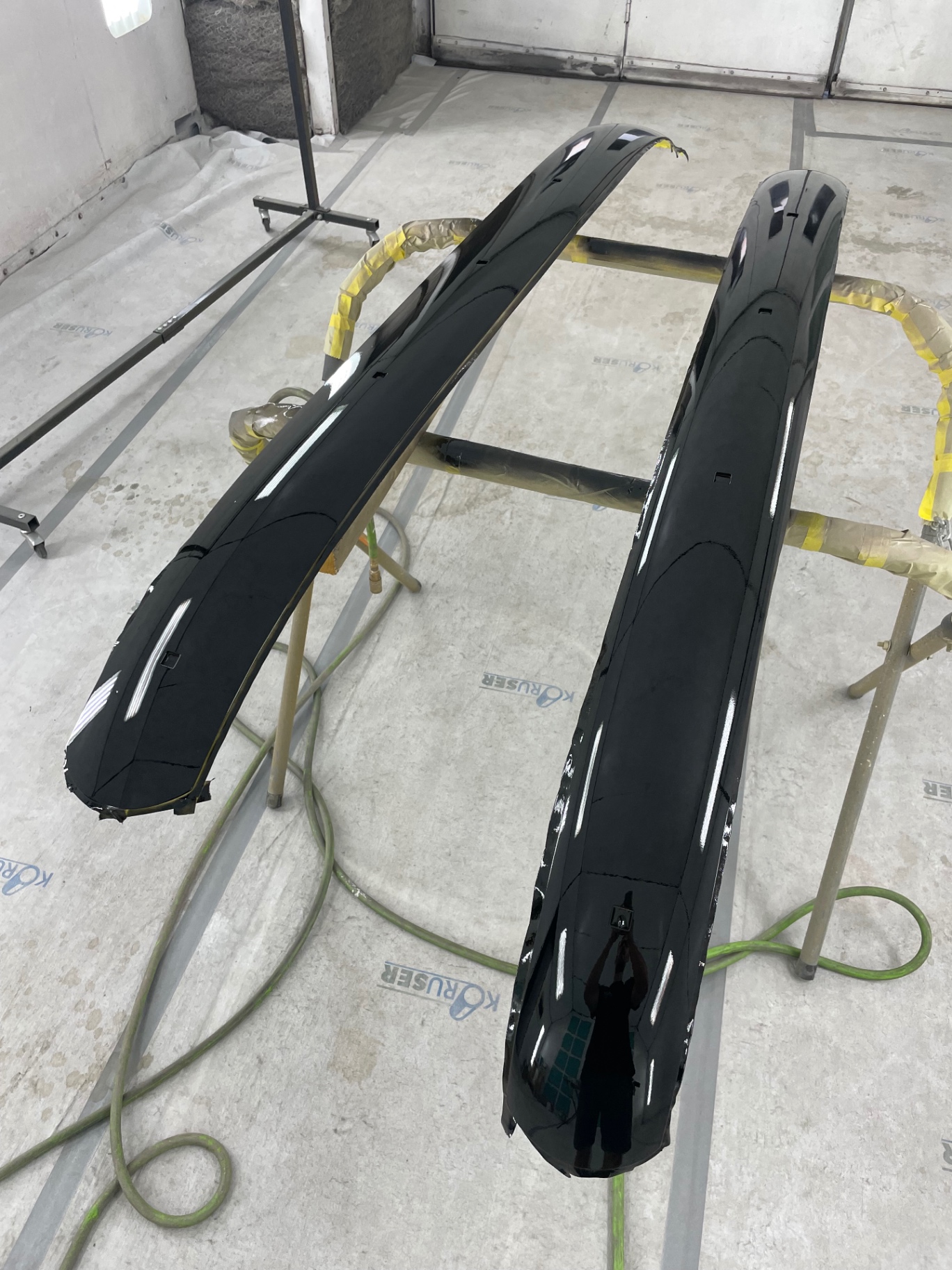 Front and rear bumpers in gloss black — the anchor to the tan body.