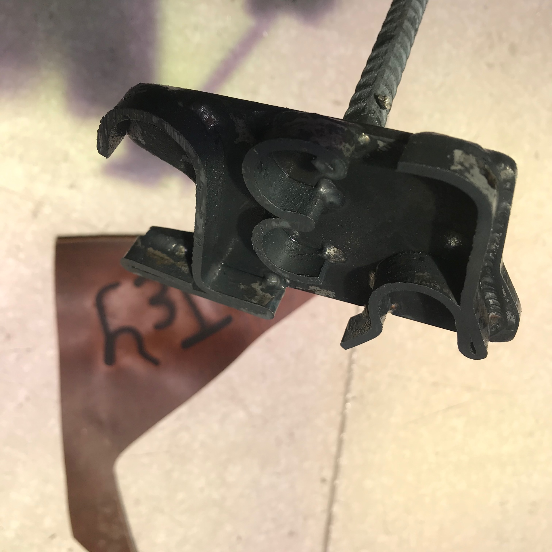 The finished brand — plate letters welded to a rebar shaft, ready for the fire.