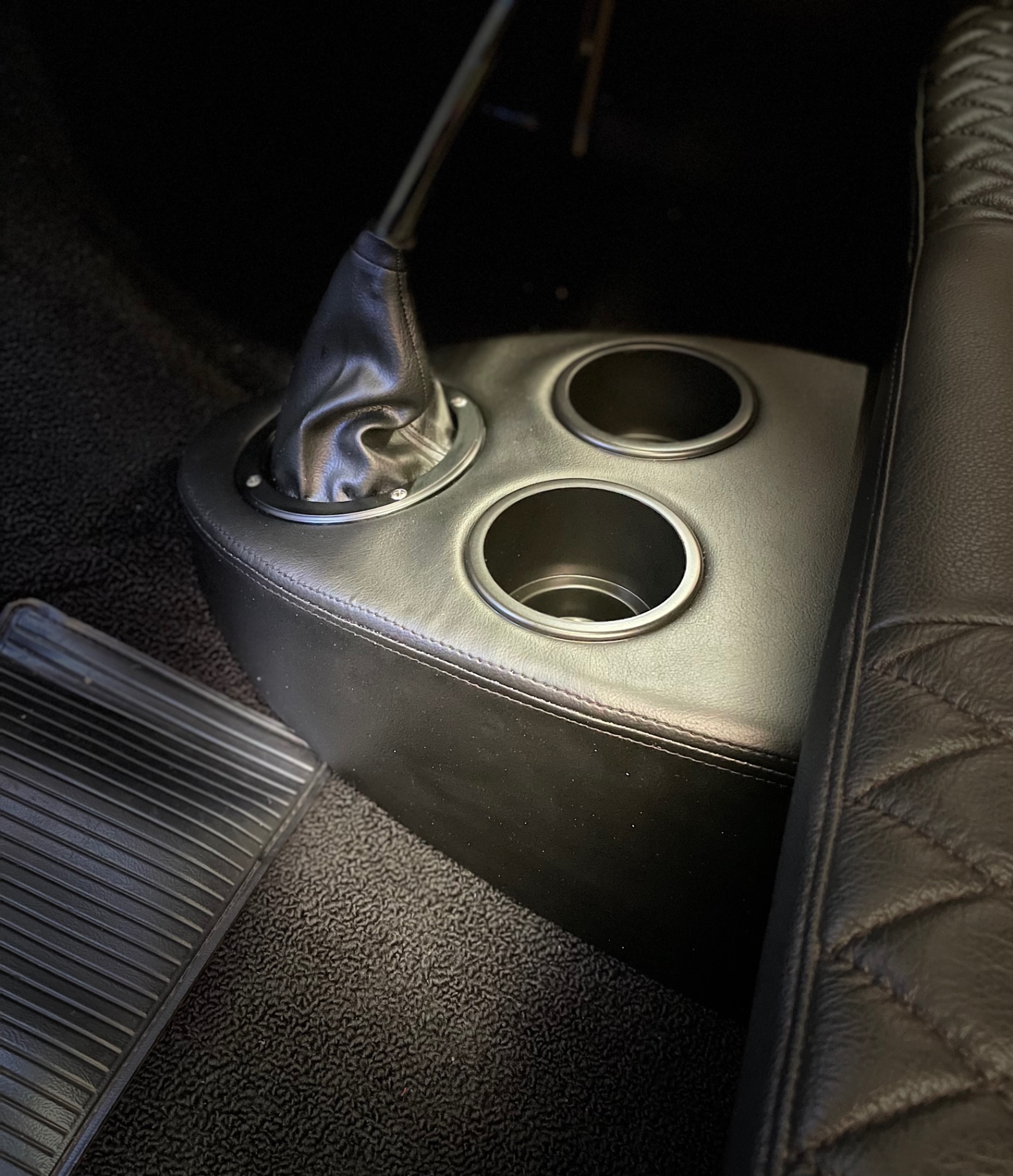 Custom leather console — cup holders and shifter boot trimmed to match the interior.