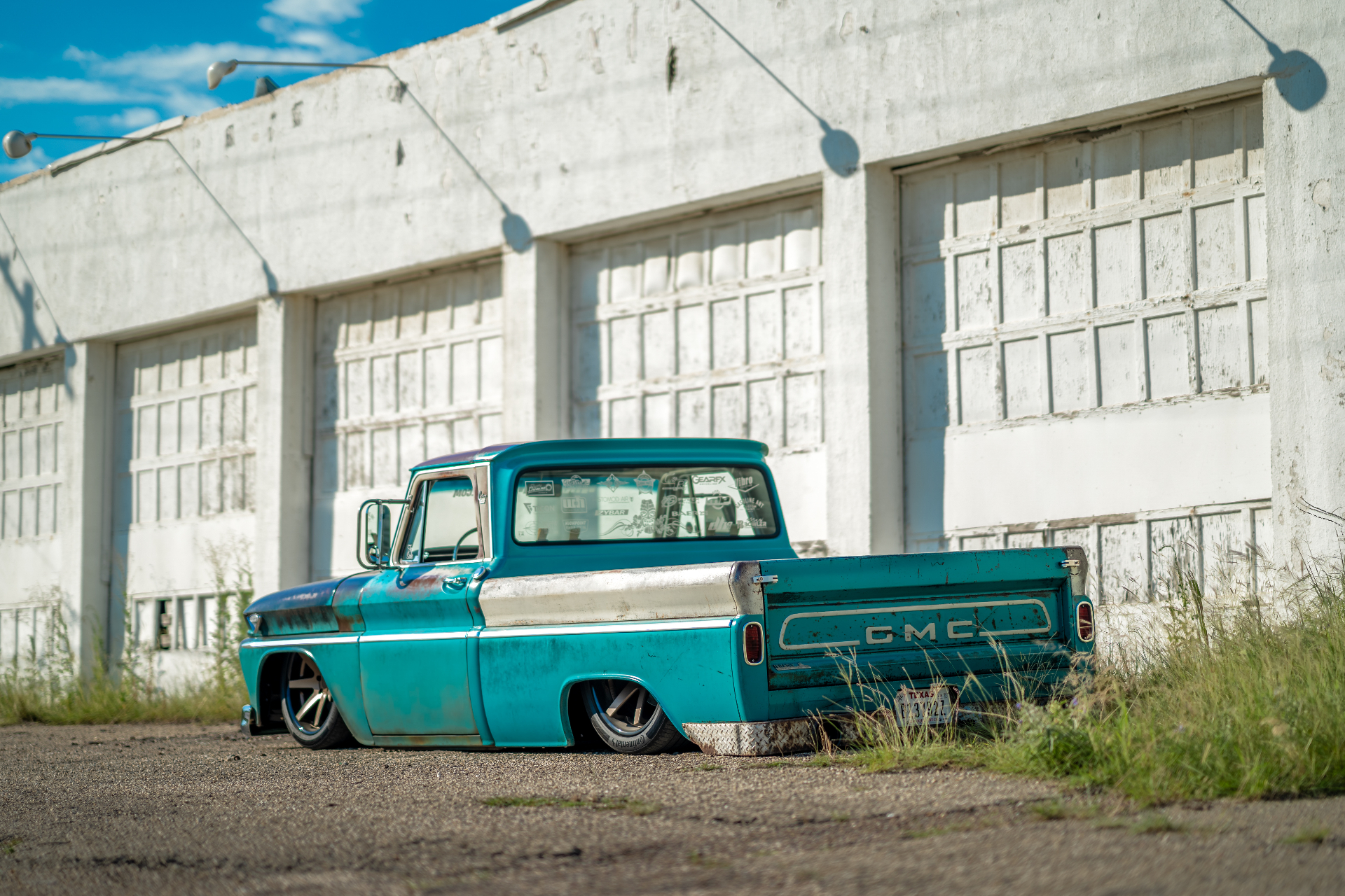 Rear three-quarter — GMC tailgate and Texas plate.