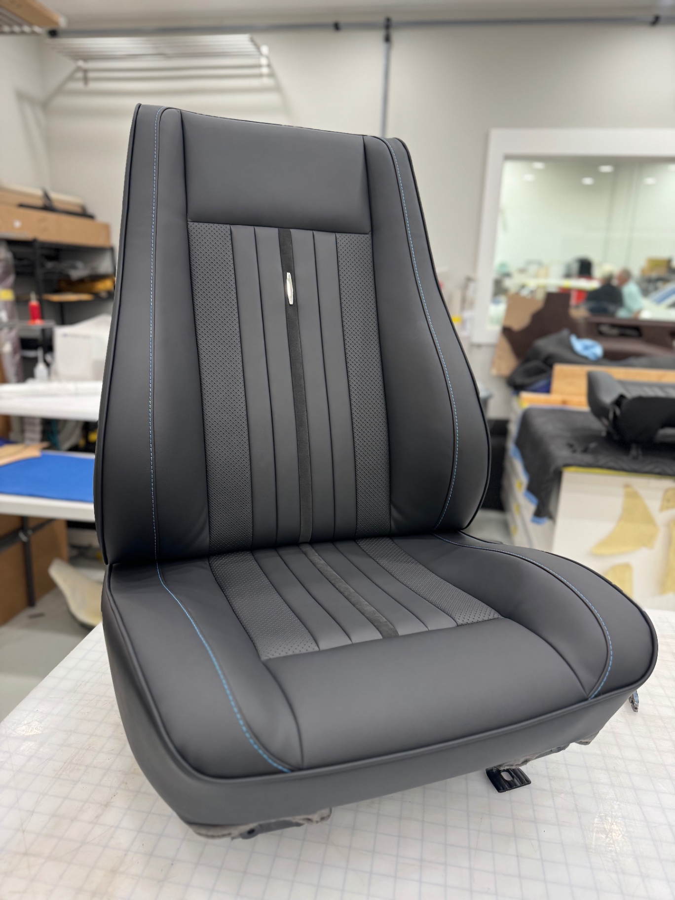 Bucket seat three-quarter — Moore & Giles leather over reshaped foam.