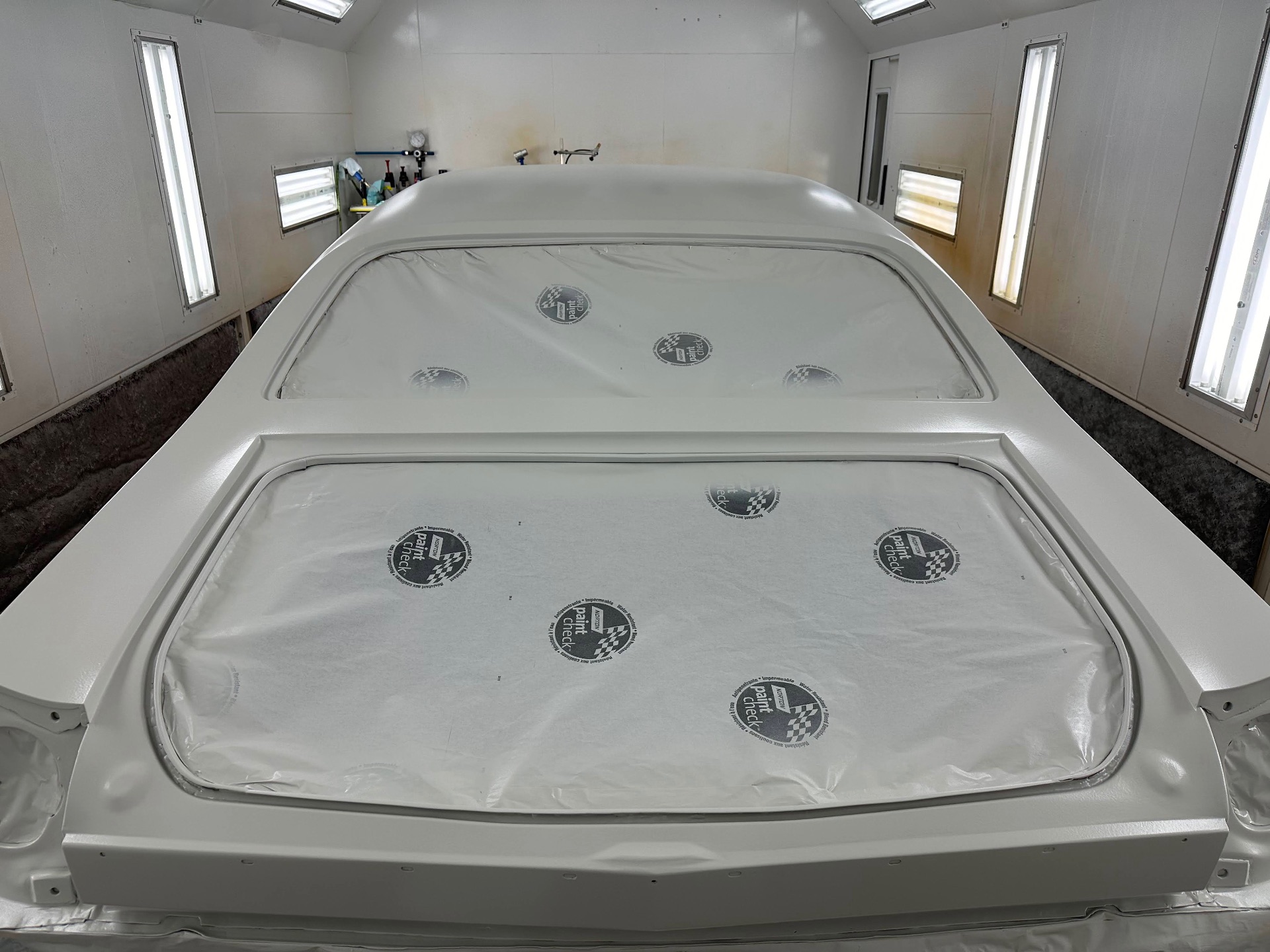 Roof and rear glass masked — full paper coverage before stripe work.