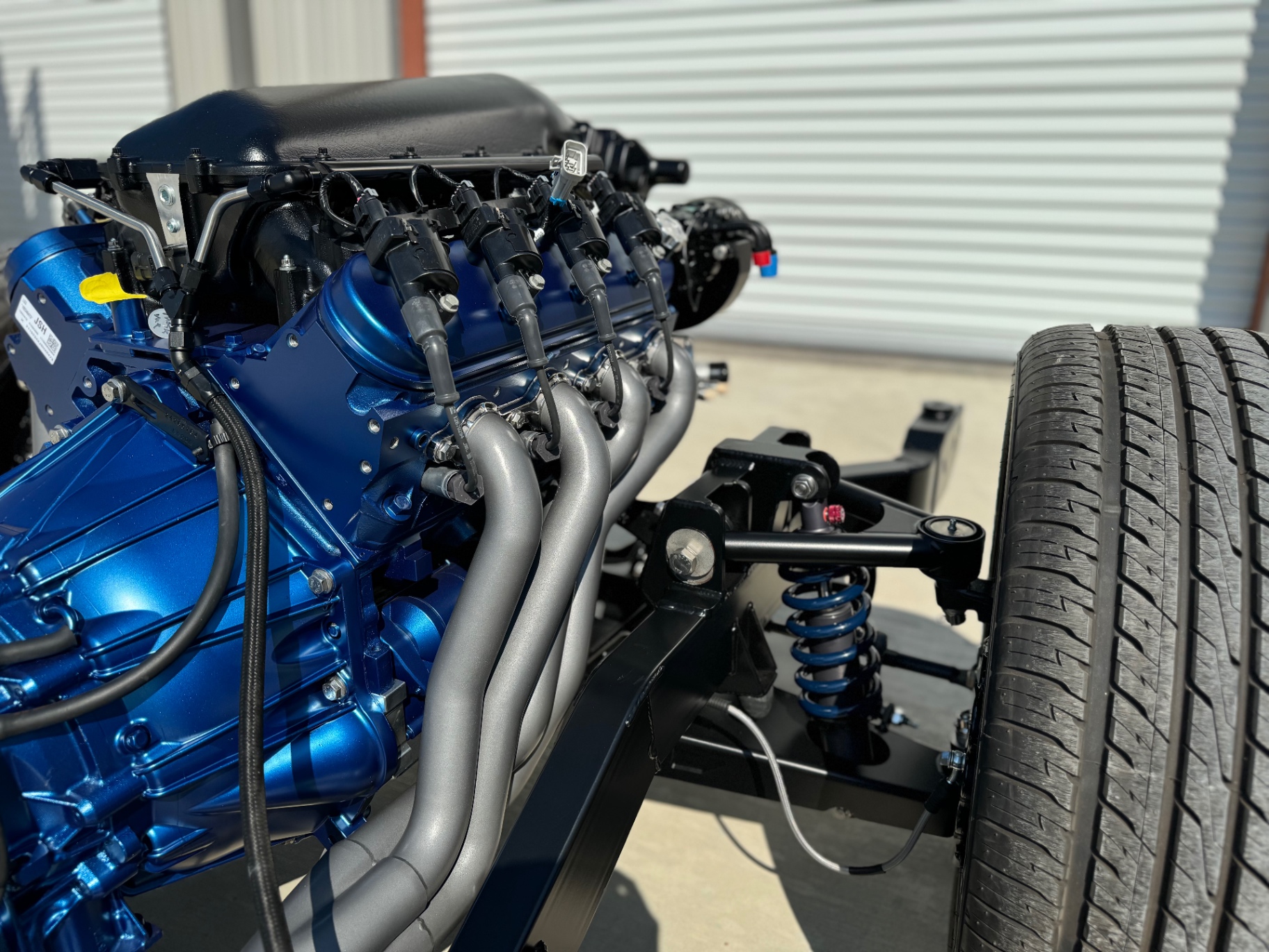 Long-tube headers and coilover front suspension on the rolling chassis.