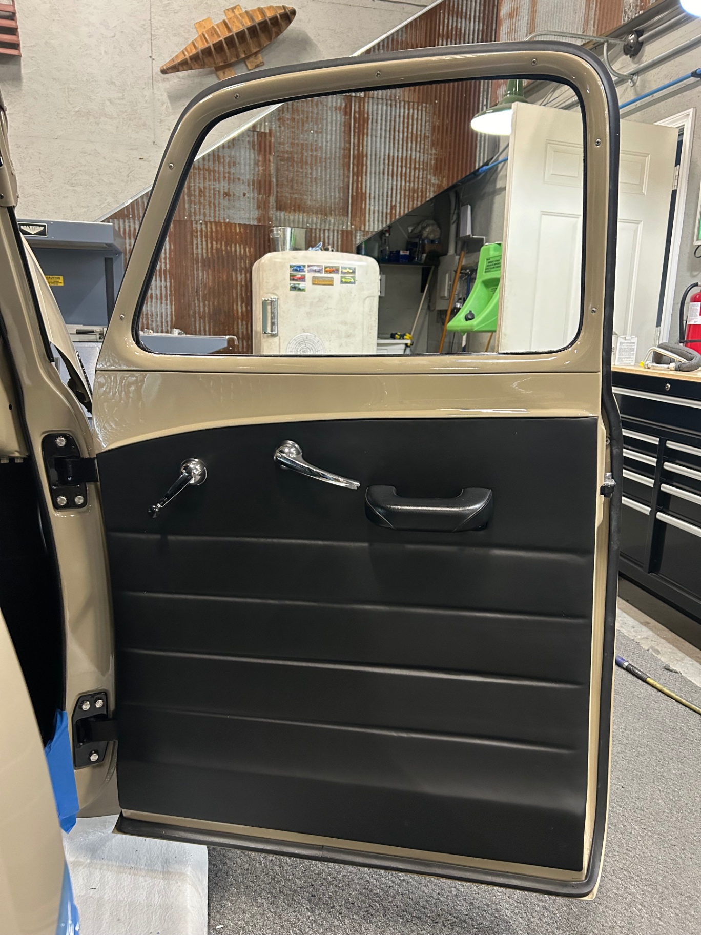 New panel installed — metal upper painted body color, fiberglass lower wrapped in black leather.